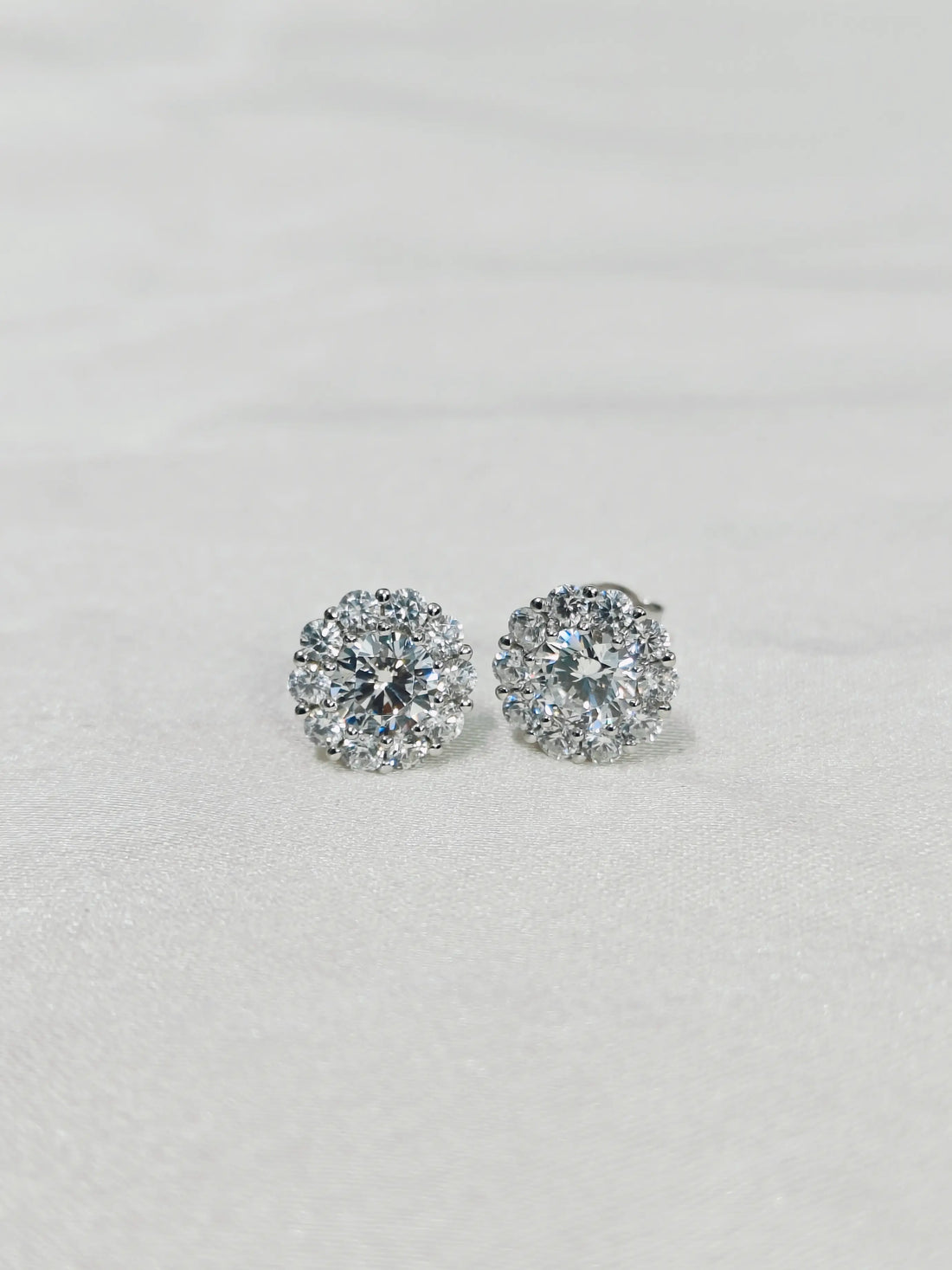Pair of diamond stud earrings on a light gray background