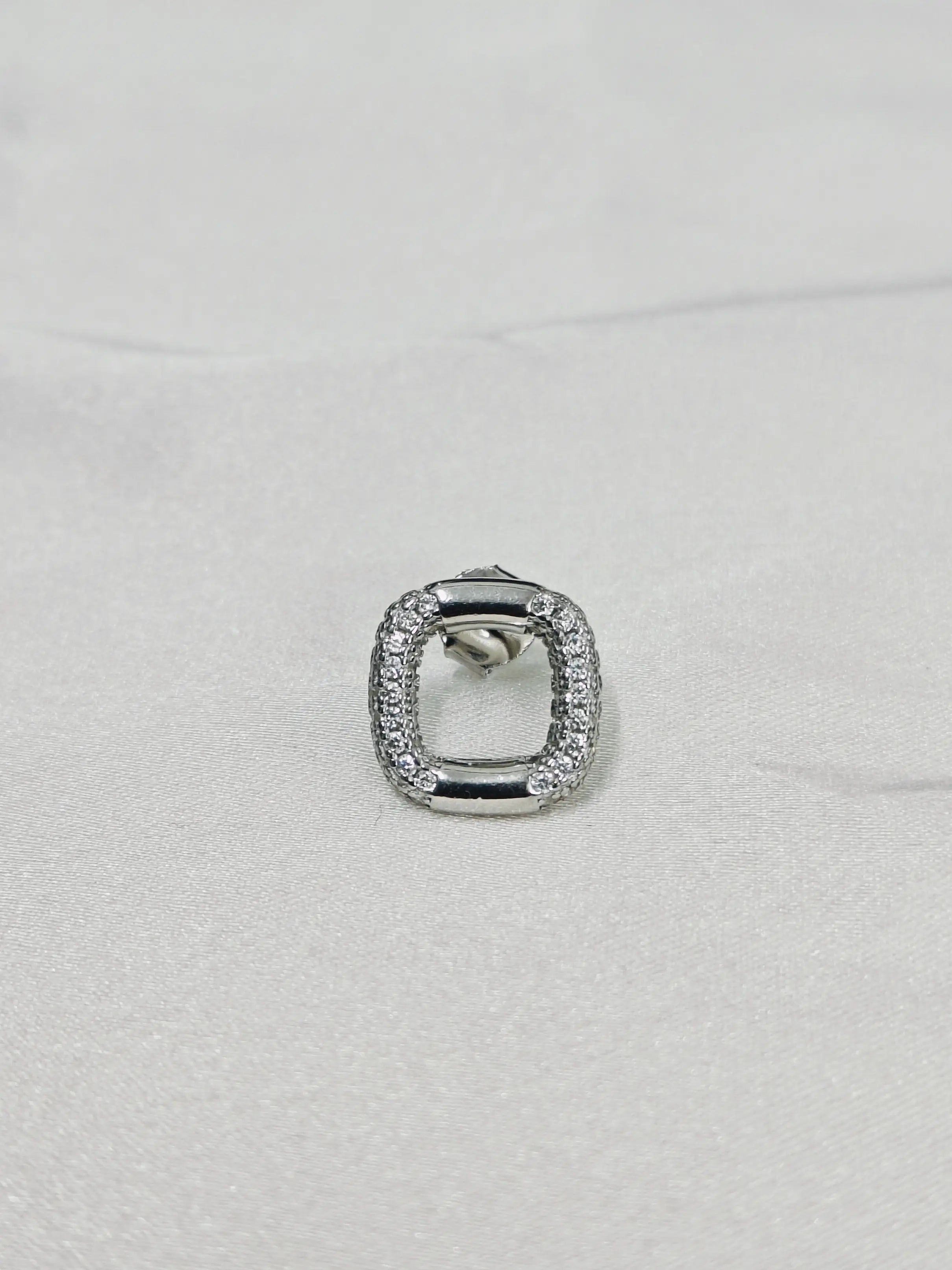 Silver ring with gemstones on a light gray background