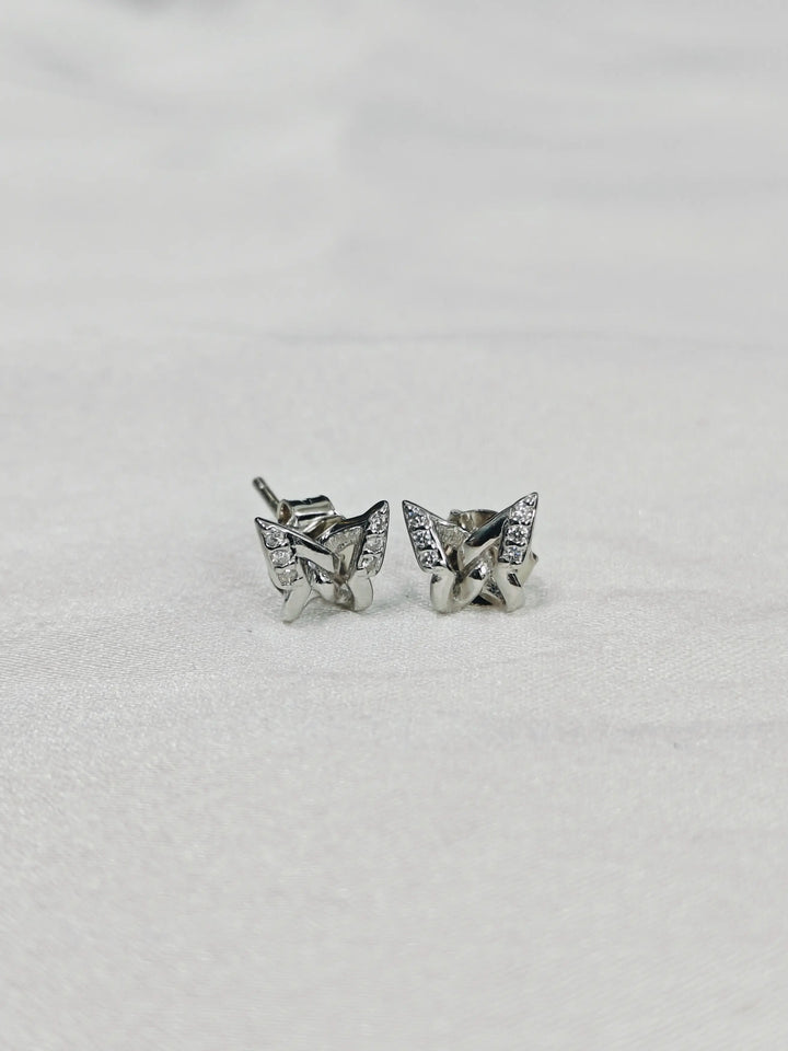 Butterfly-shaped silver earrings on a light gray background