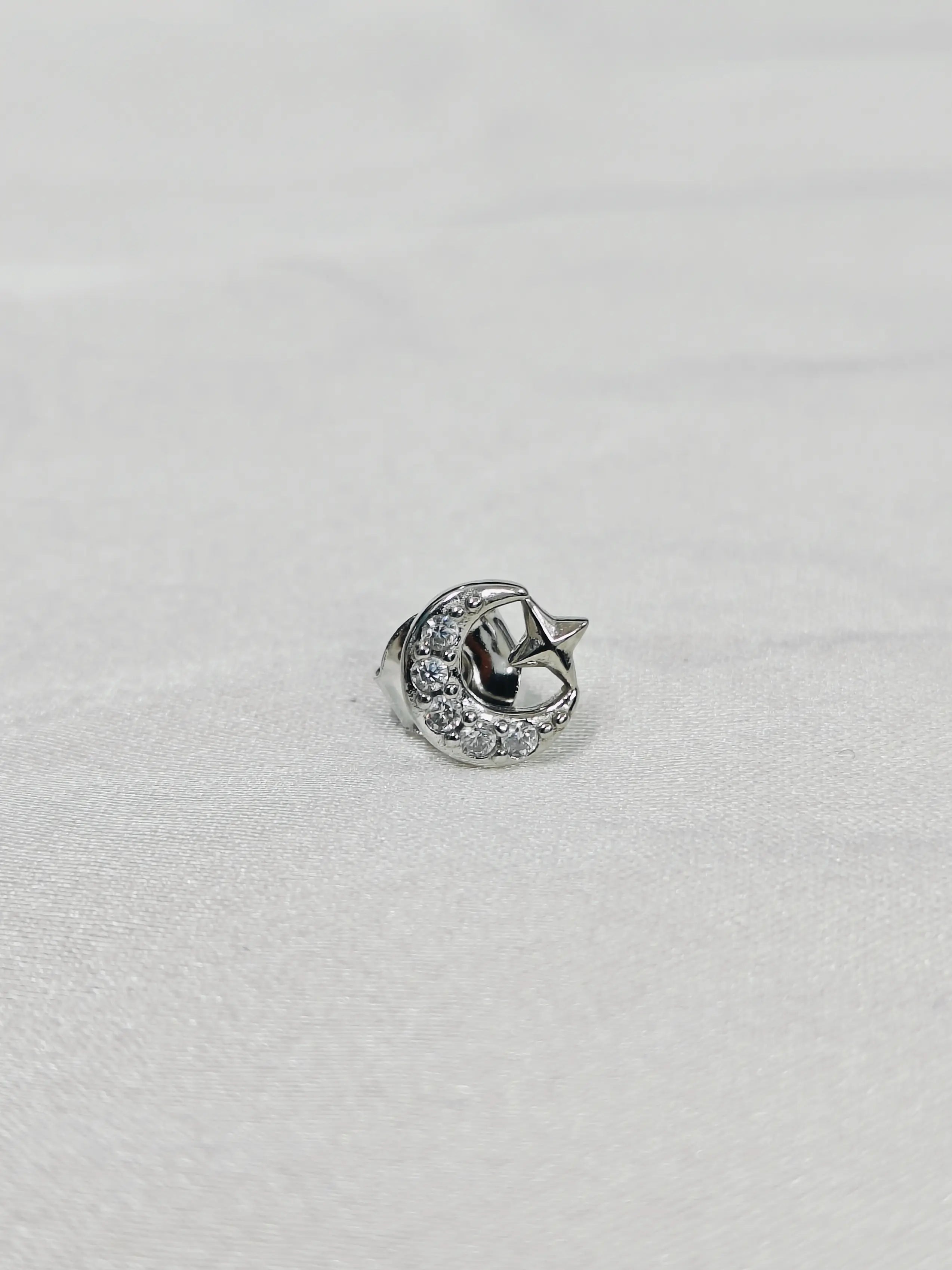 Silver ring with a crescent moon design on a light gray background