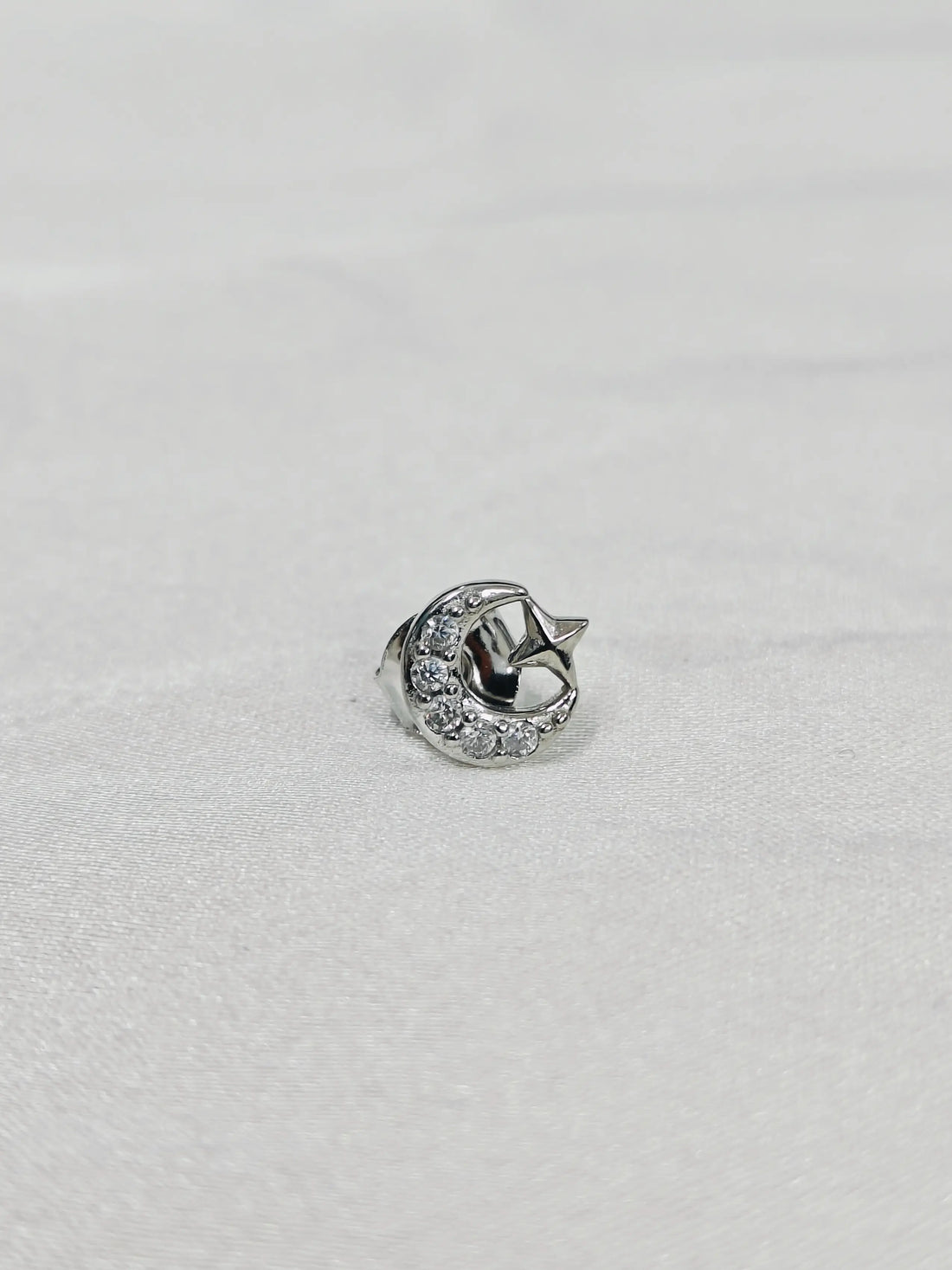 Silver ring with a crescent moon design on a light gray background