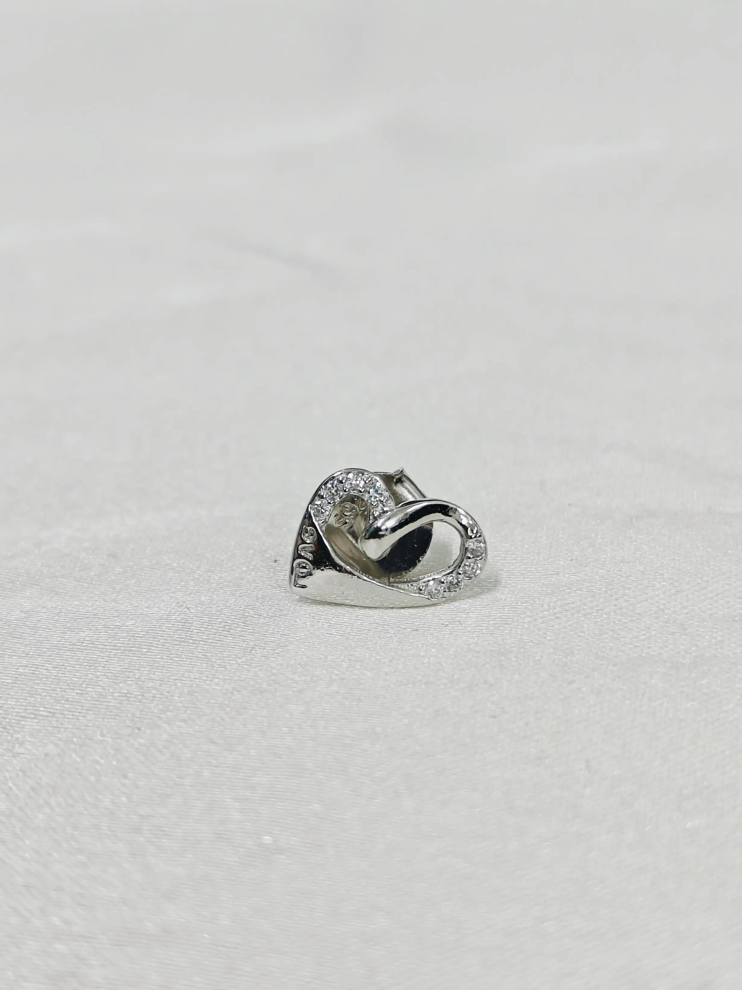 Silver ring with a diamond on a light gray background