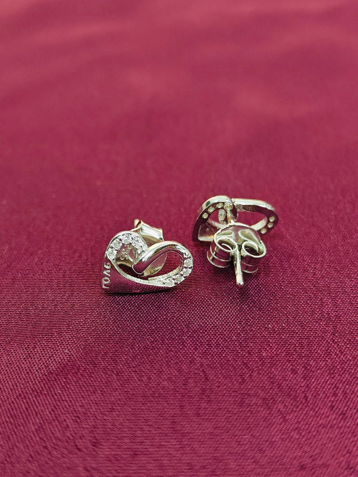 Pair of silver earrings on a red fabric background