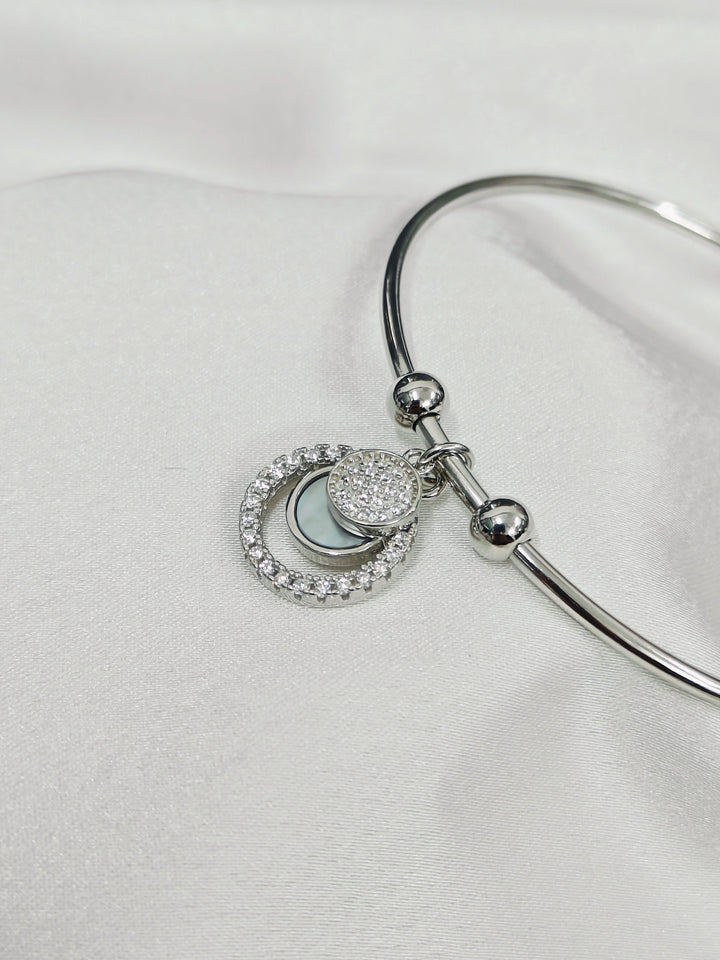 Silver bracelet with heart-shaped charm on a white background