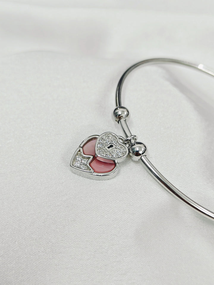 Silver bangle with heart-shaped charms on a white background