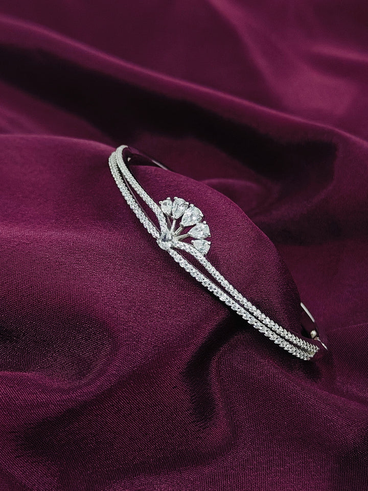 Silver headband with a decorative design on a purple fabric background