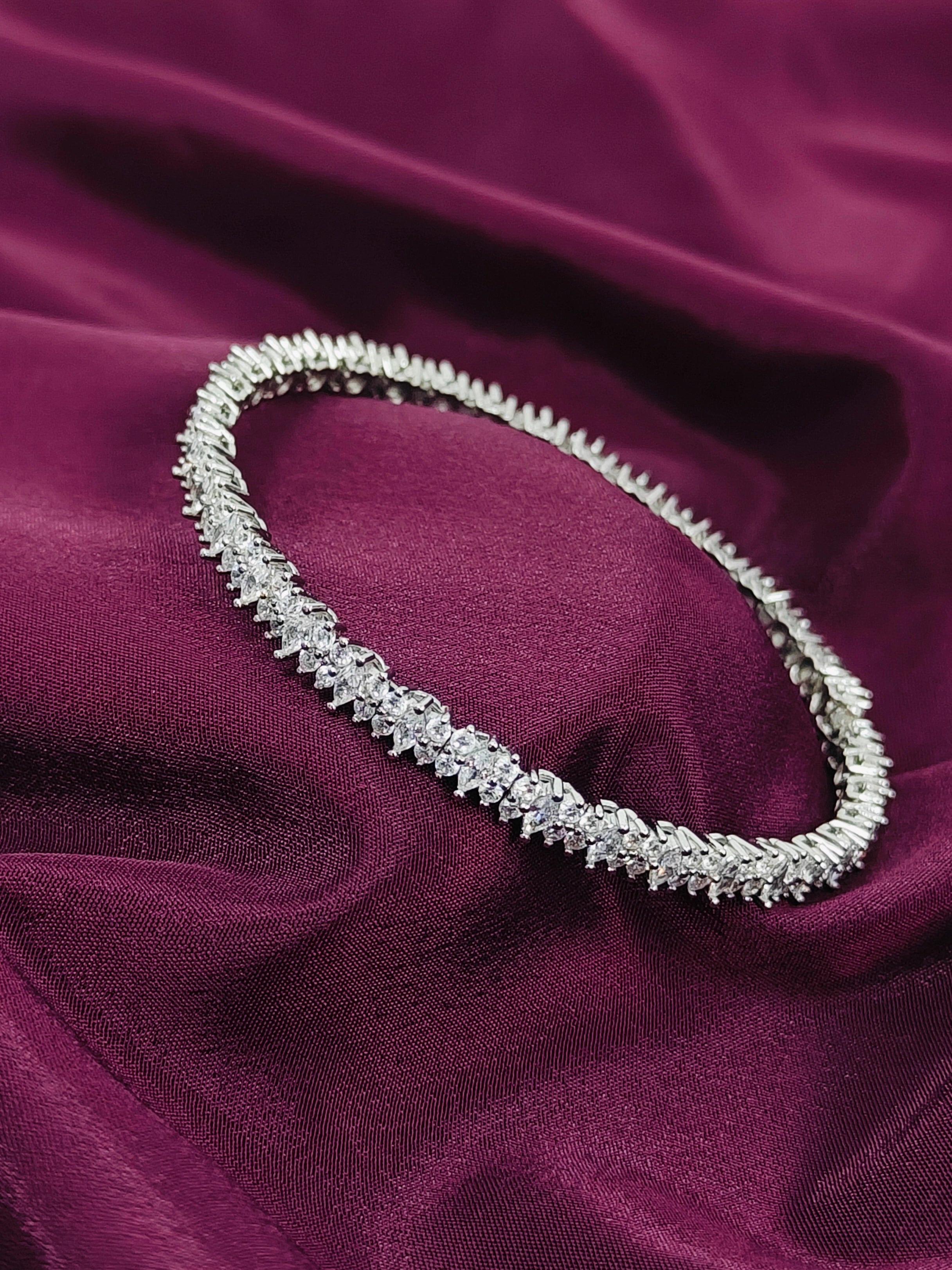 Silver necklace on a purple fabric background