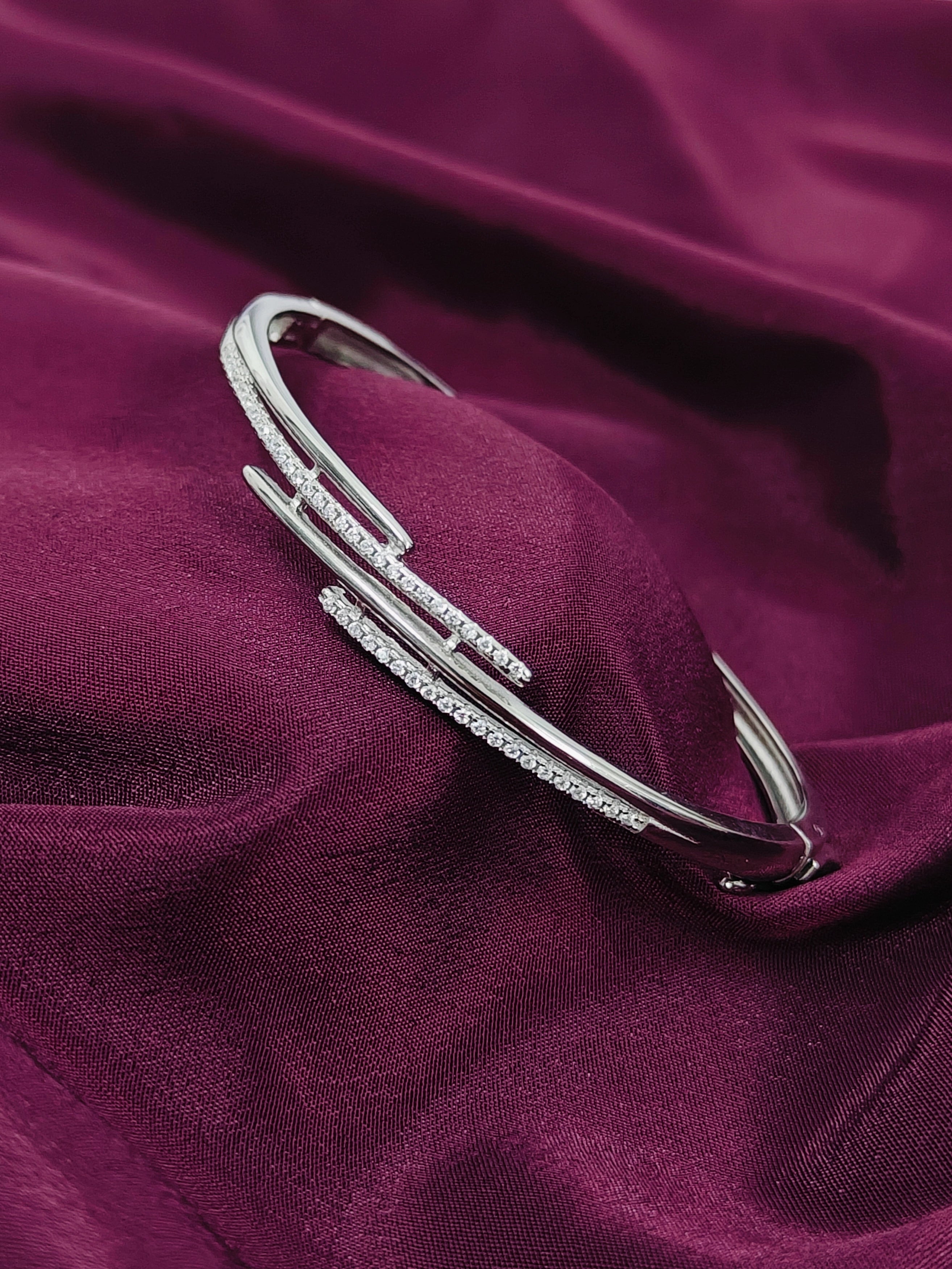 Silver bracelet with small stones on a purple fabric background