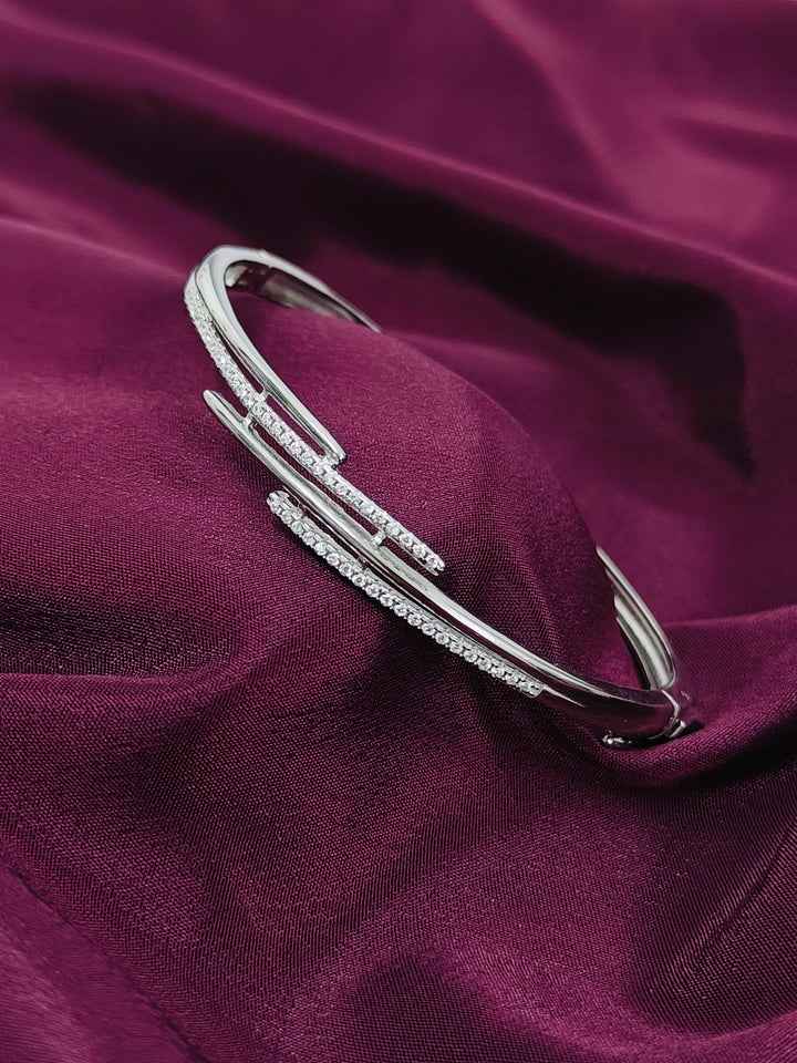 Silver bracelet with small stones on a purple fabric background