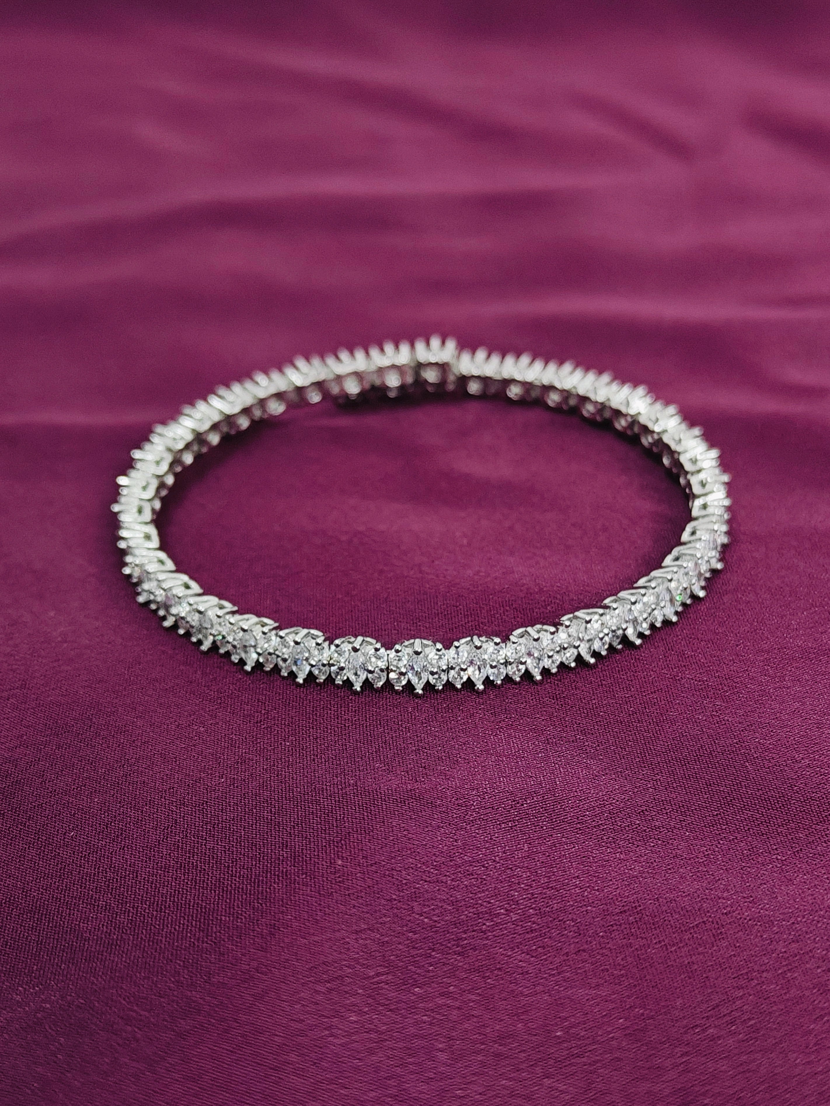 Silver bracelet with clear stones on a purple fabric background