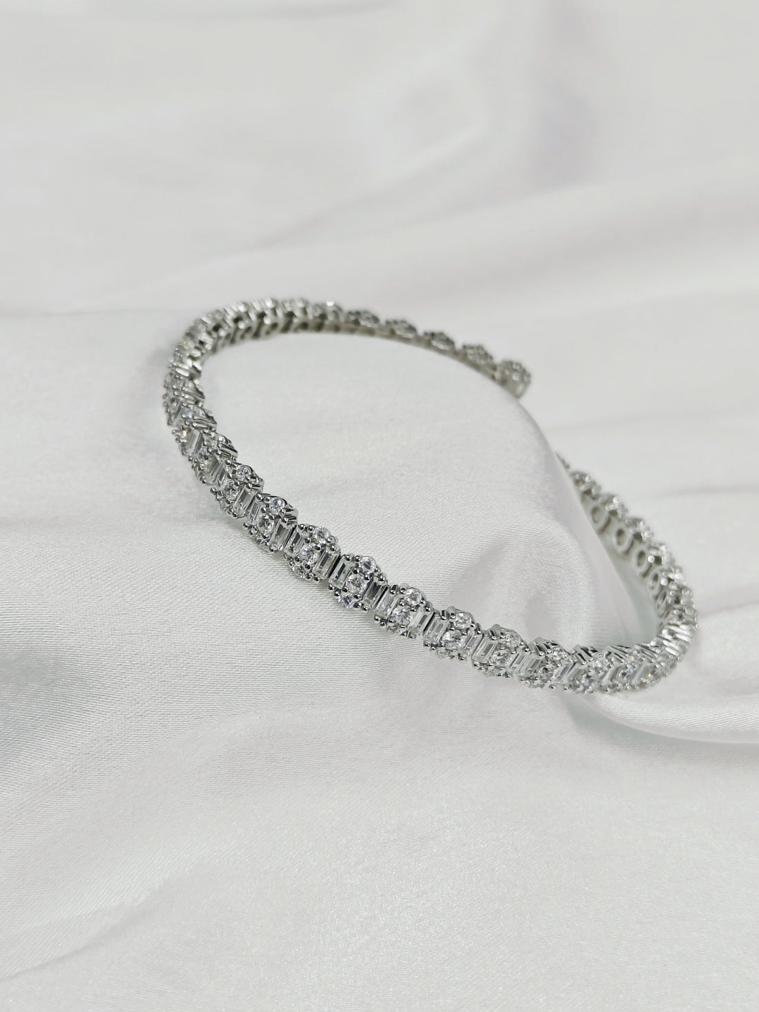 Silver bracelet on a white fabric background