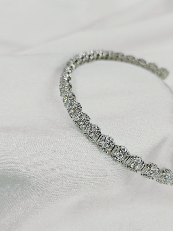 Silver bracelet with clear stones on a light gray background