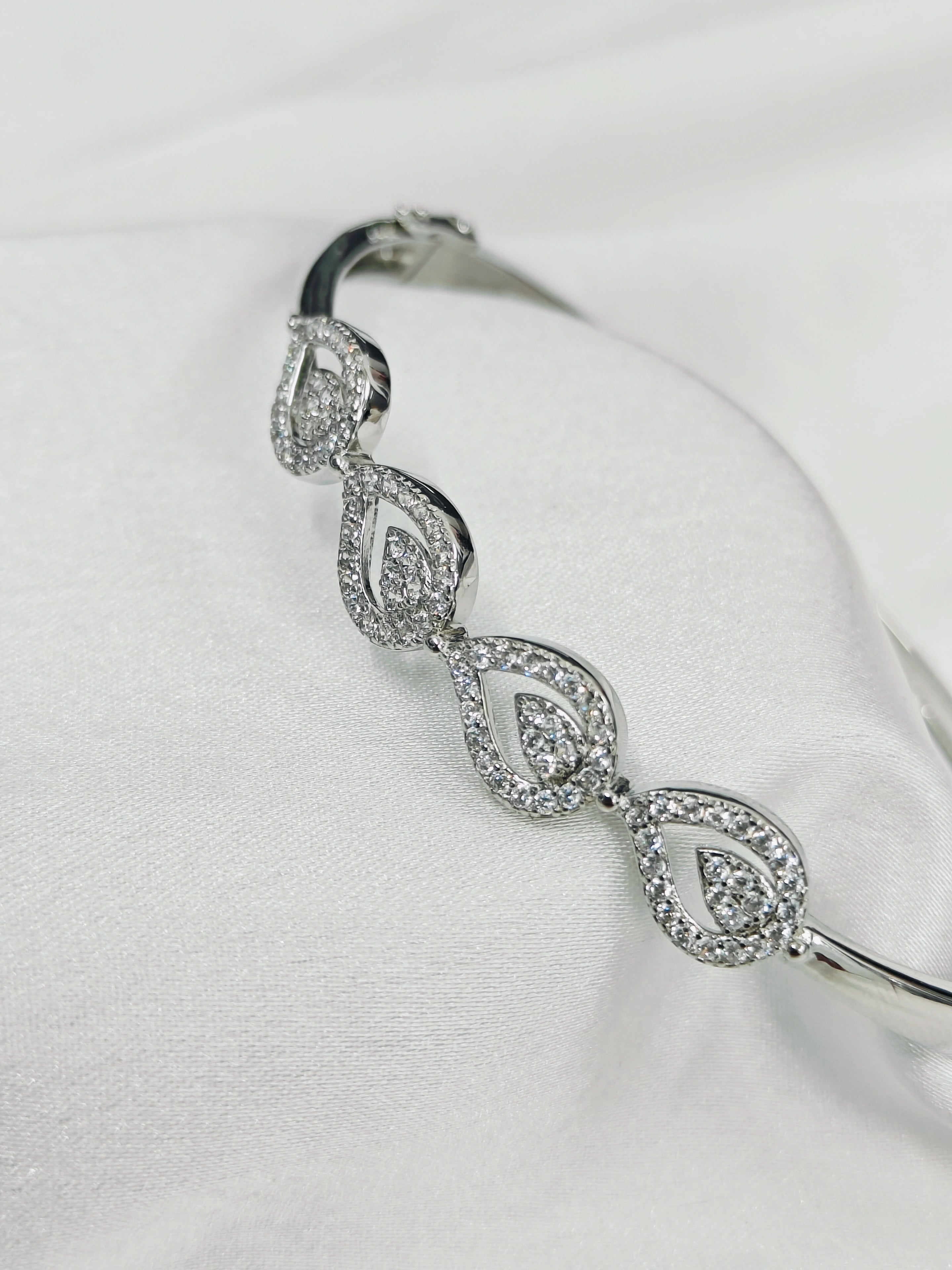 Silver bracelet with diamond-like stones on a white background