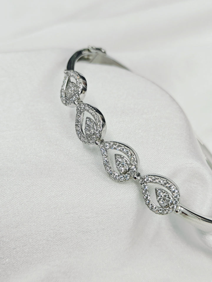 Silver bracelet with diamond-like stones on a white background