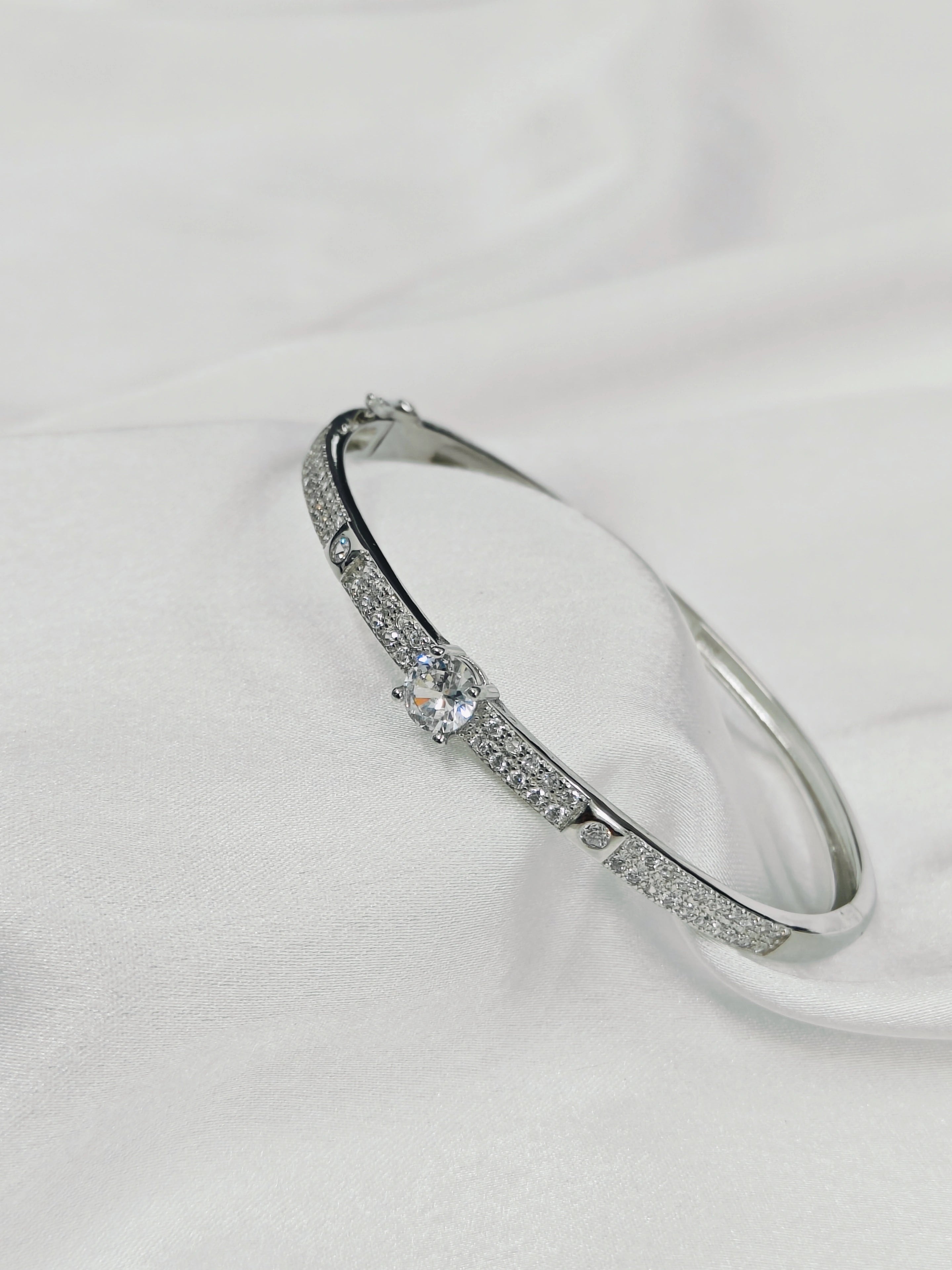 Silver bracelet with a central gemstone on a white background