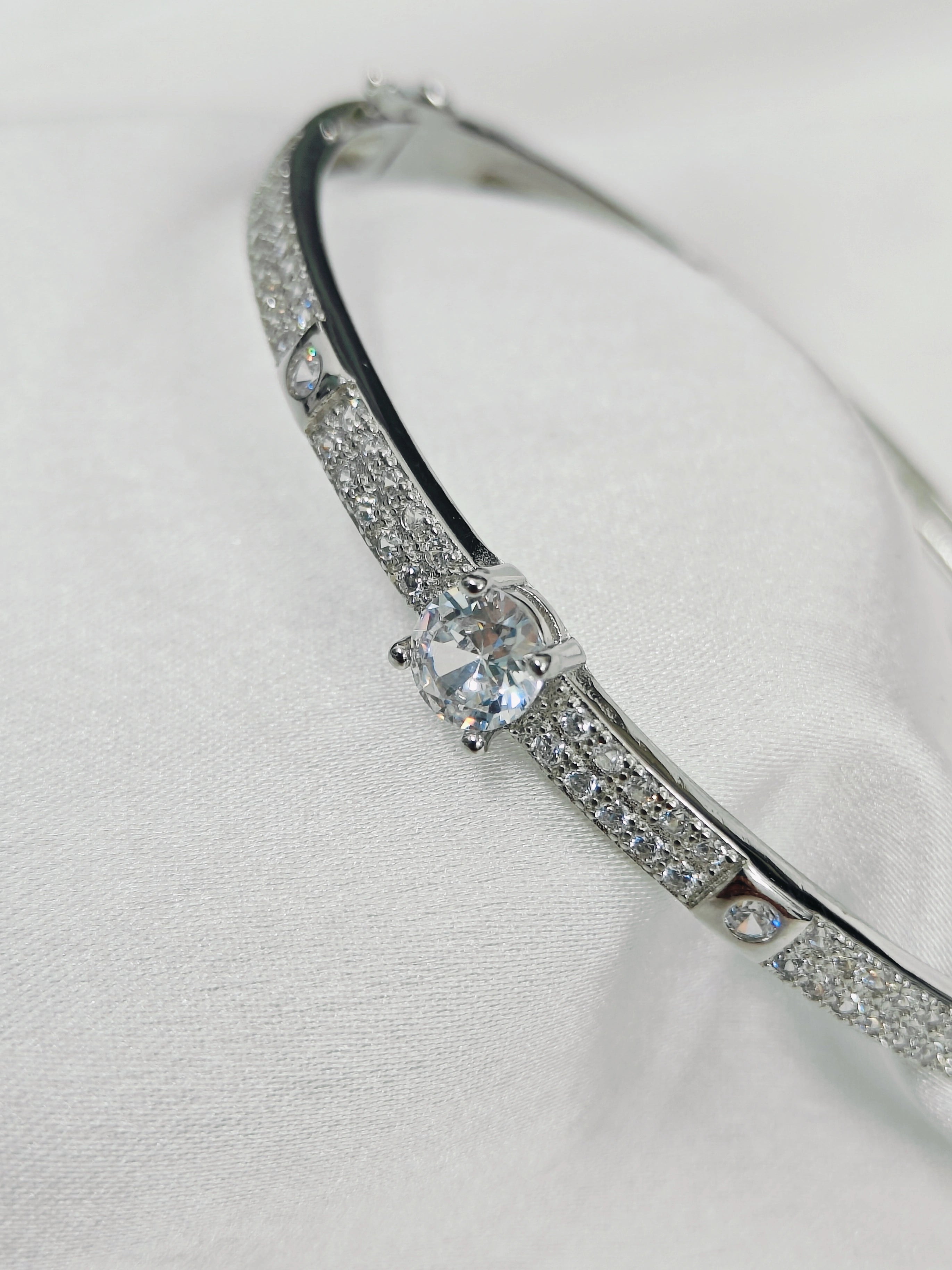 Silver bracelet with a central gemstone on a white background