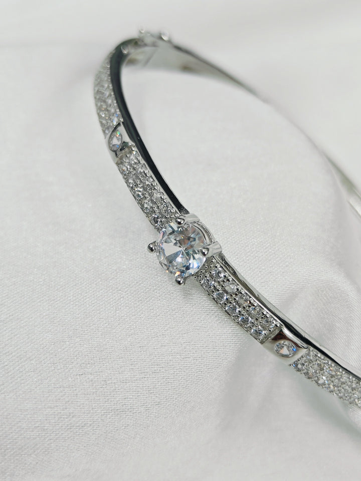 Silver bracelet with a central gemstone on a white background