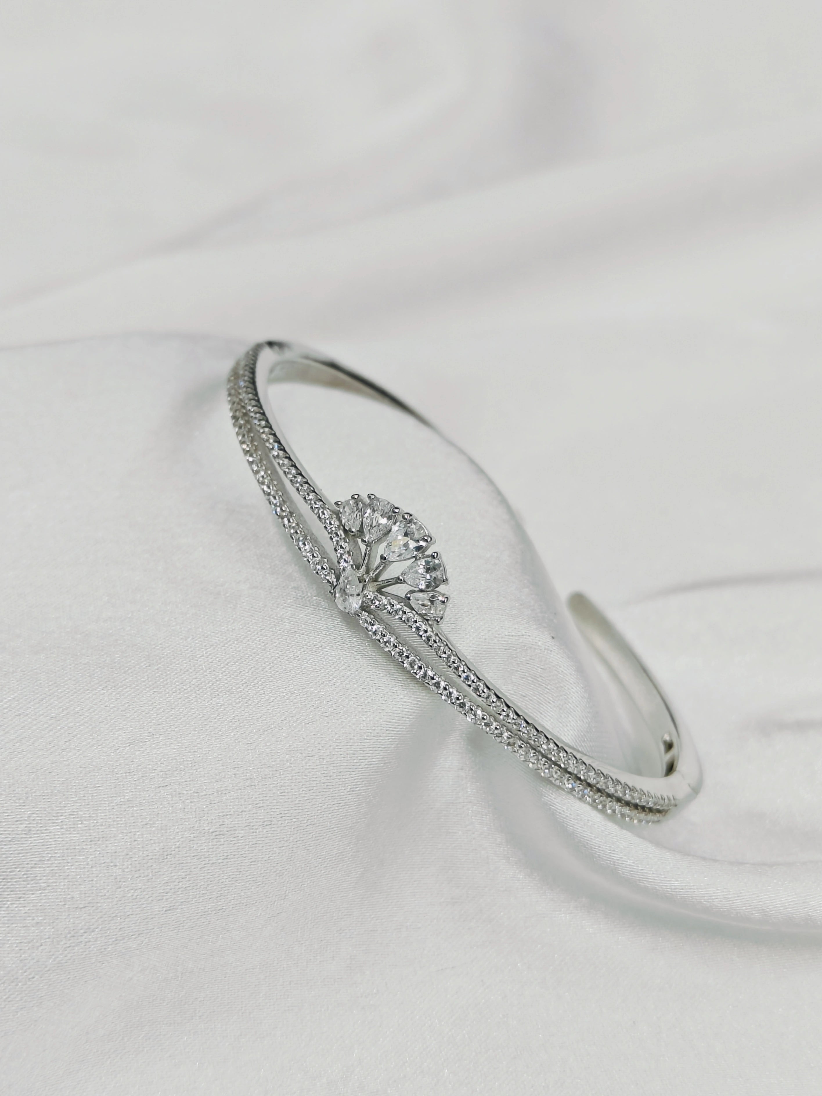 Silver bracelet with a central gemstone on a light gray background