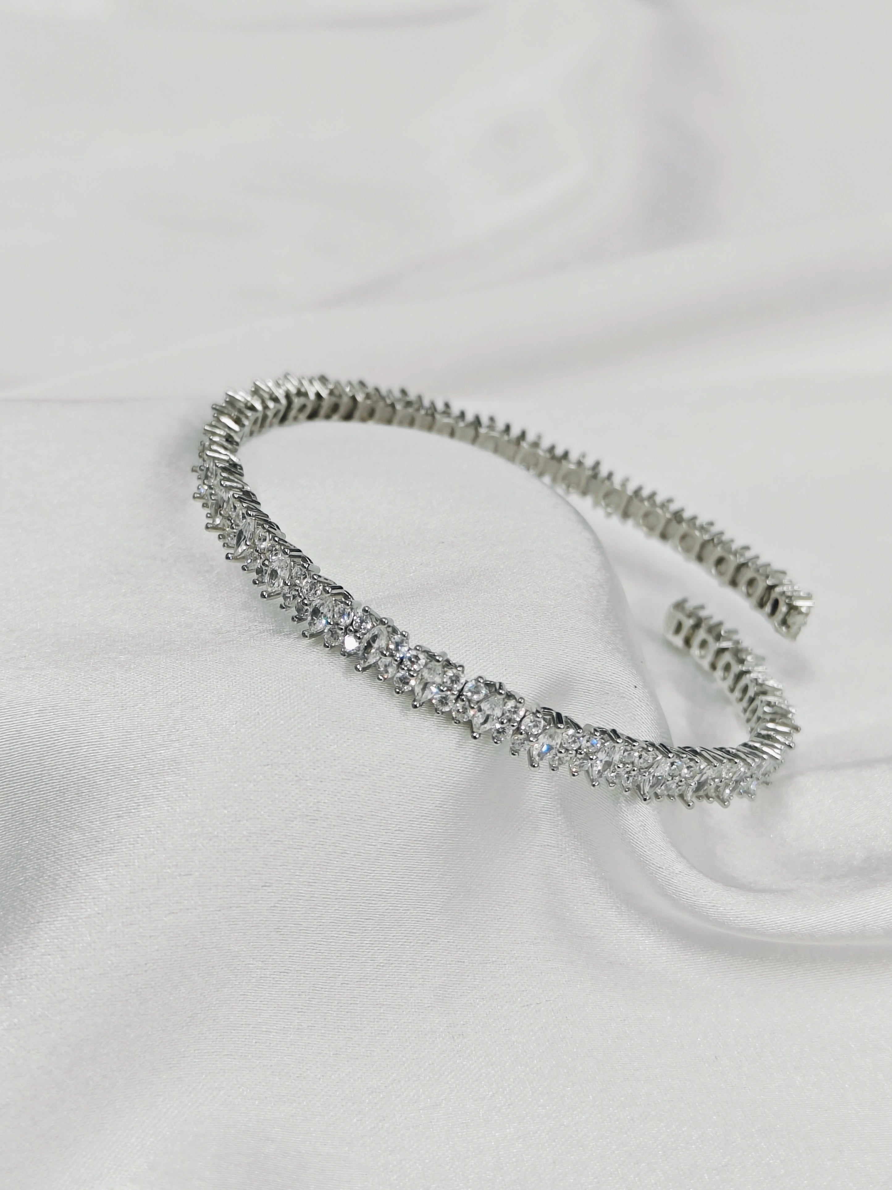 Silver headband with crystals on a white fabric background