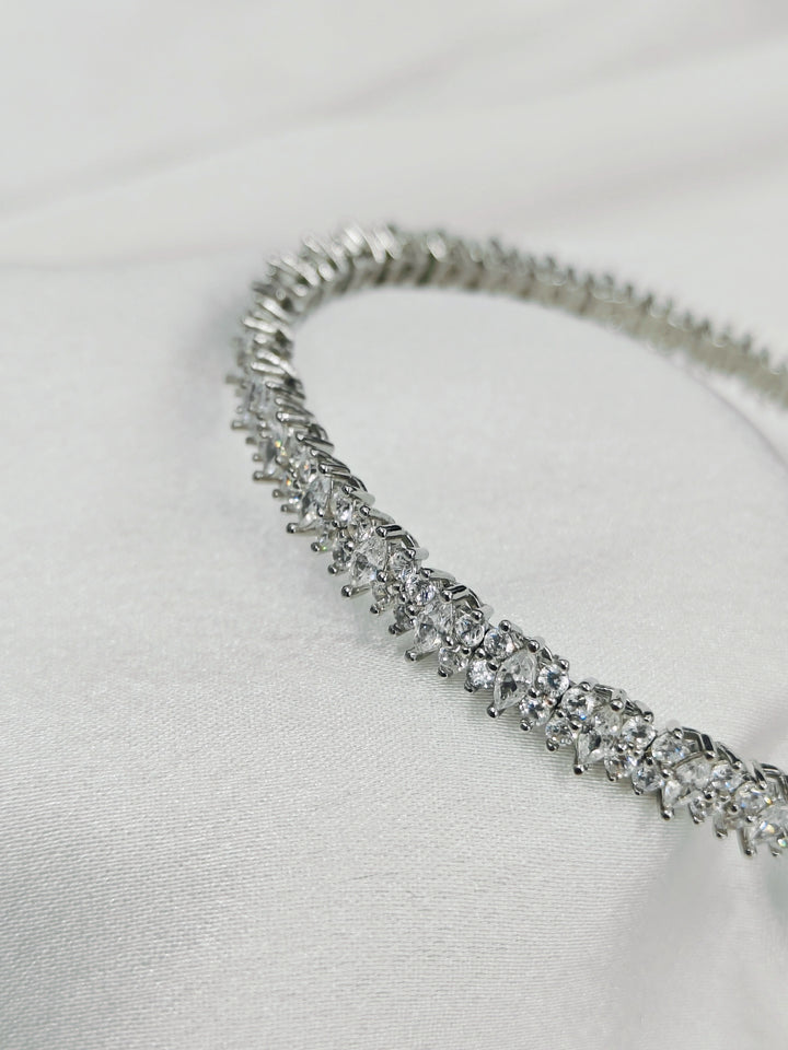 Silver bracelet with clear stones on a light gray background