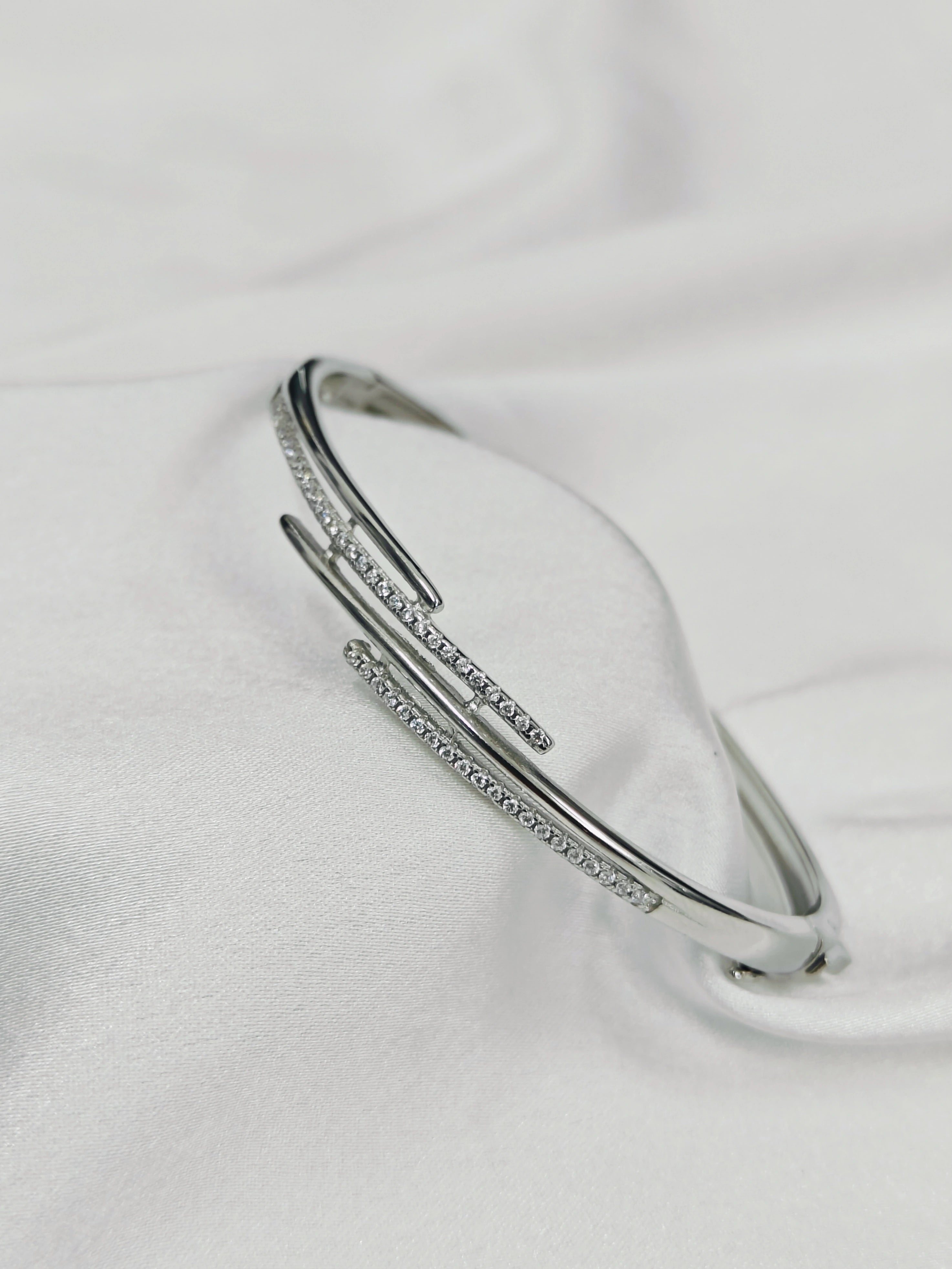 Silver bracelet with small stones on a light gray background