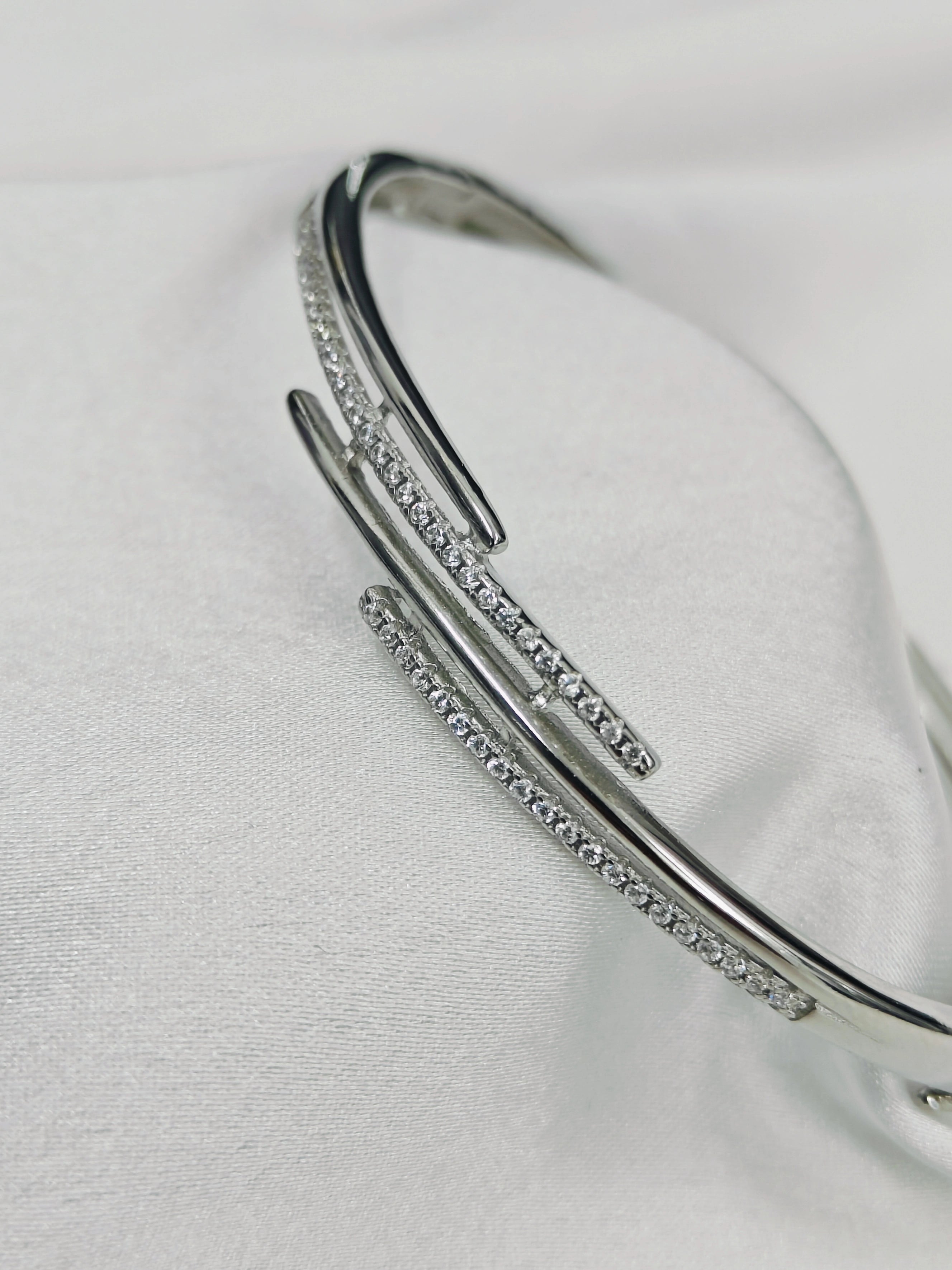 Silver bracelet with small stones on a light gray background