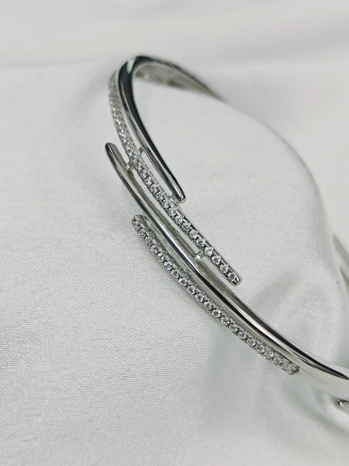 Silver bracelet with small stones on a light gray background