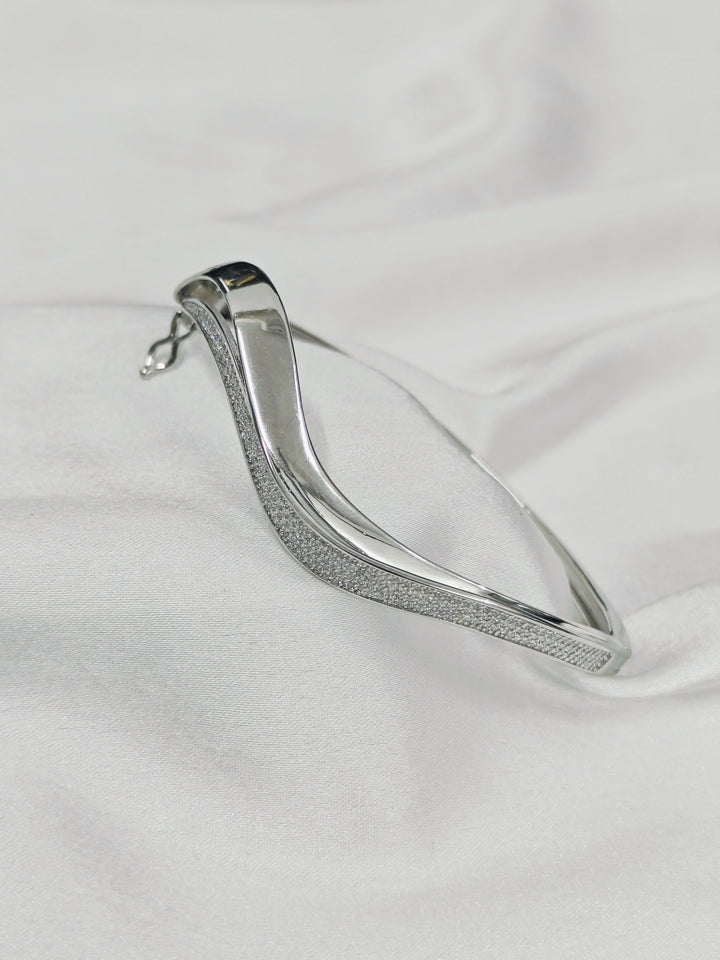 Silver bracelet on a white fabric background