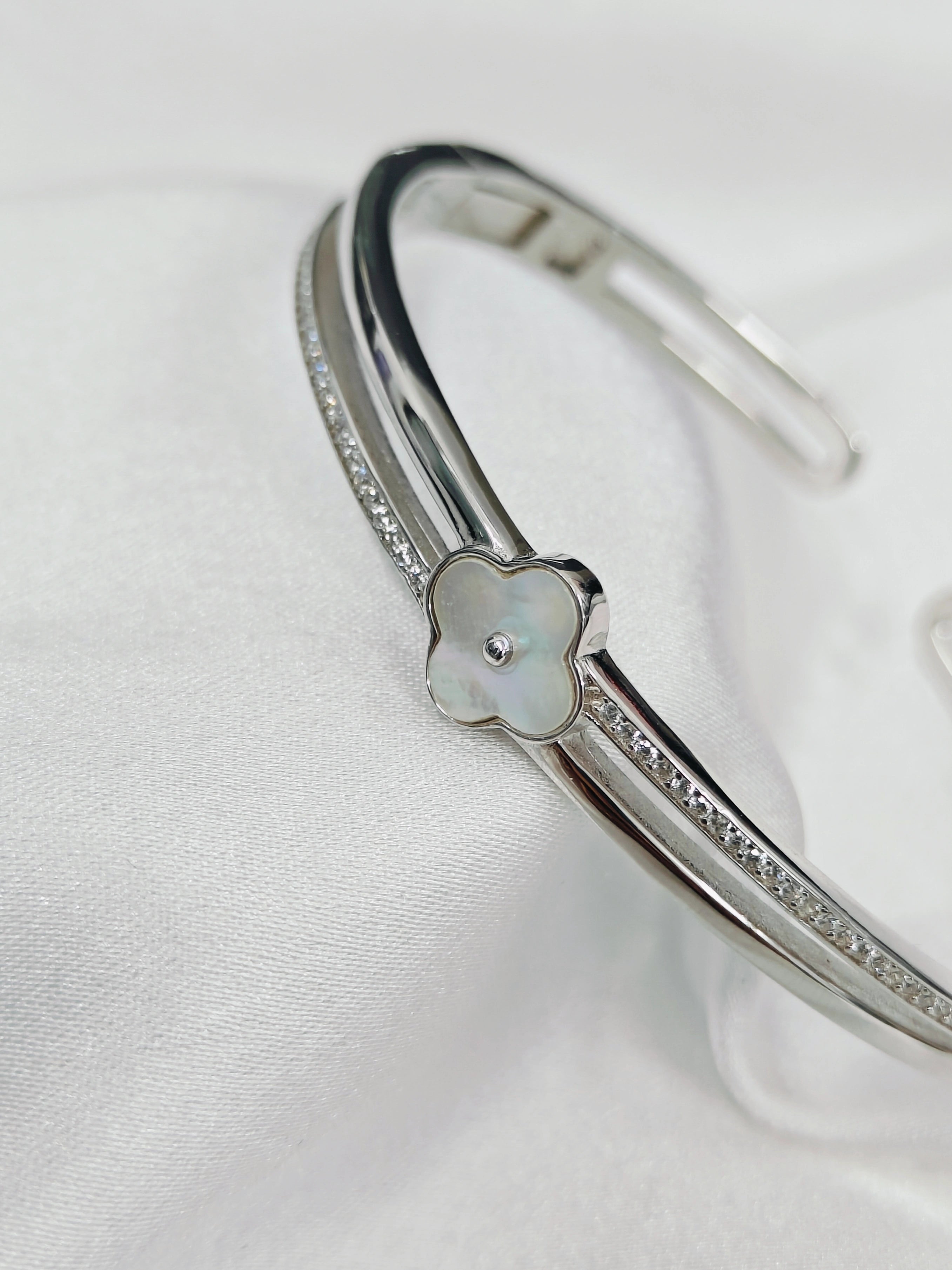 Silver bracelet with a floral design on a white background