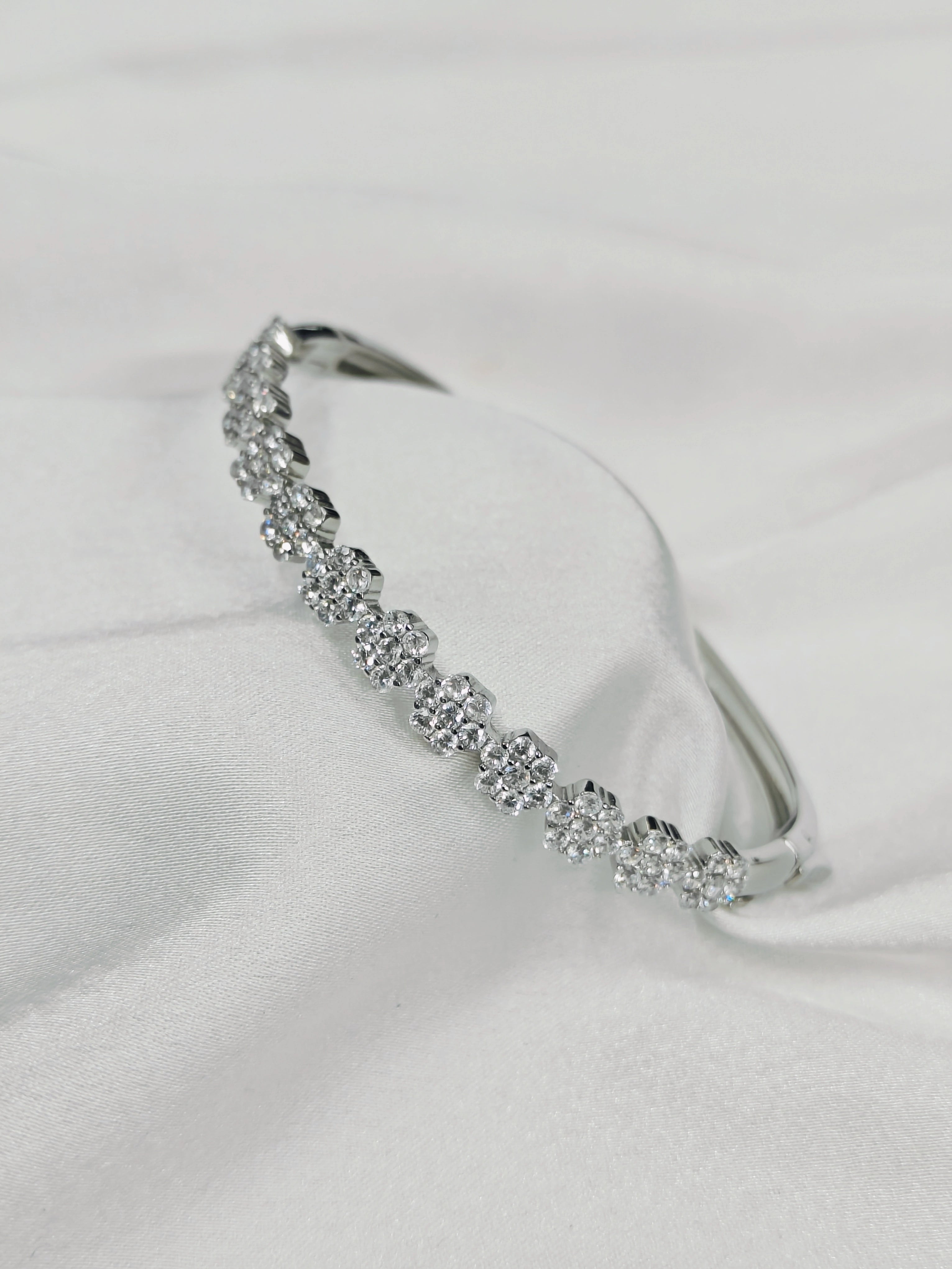 Silver headband with crystals on a white fabric background