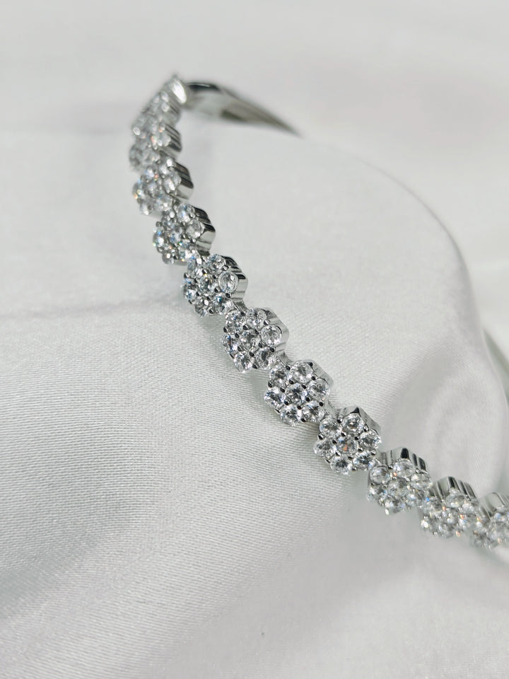 Silver bracelet with clear stones on a white fabric background