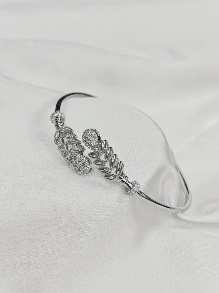 Silver bracelet with floral design on a white background