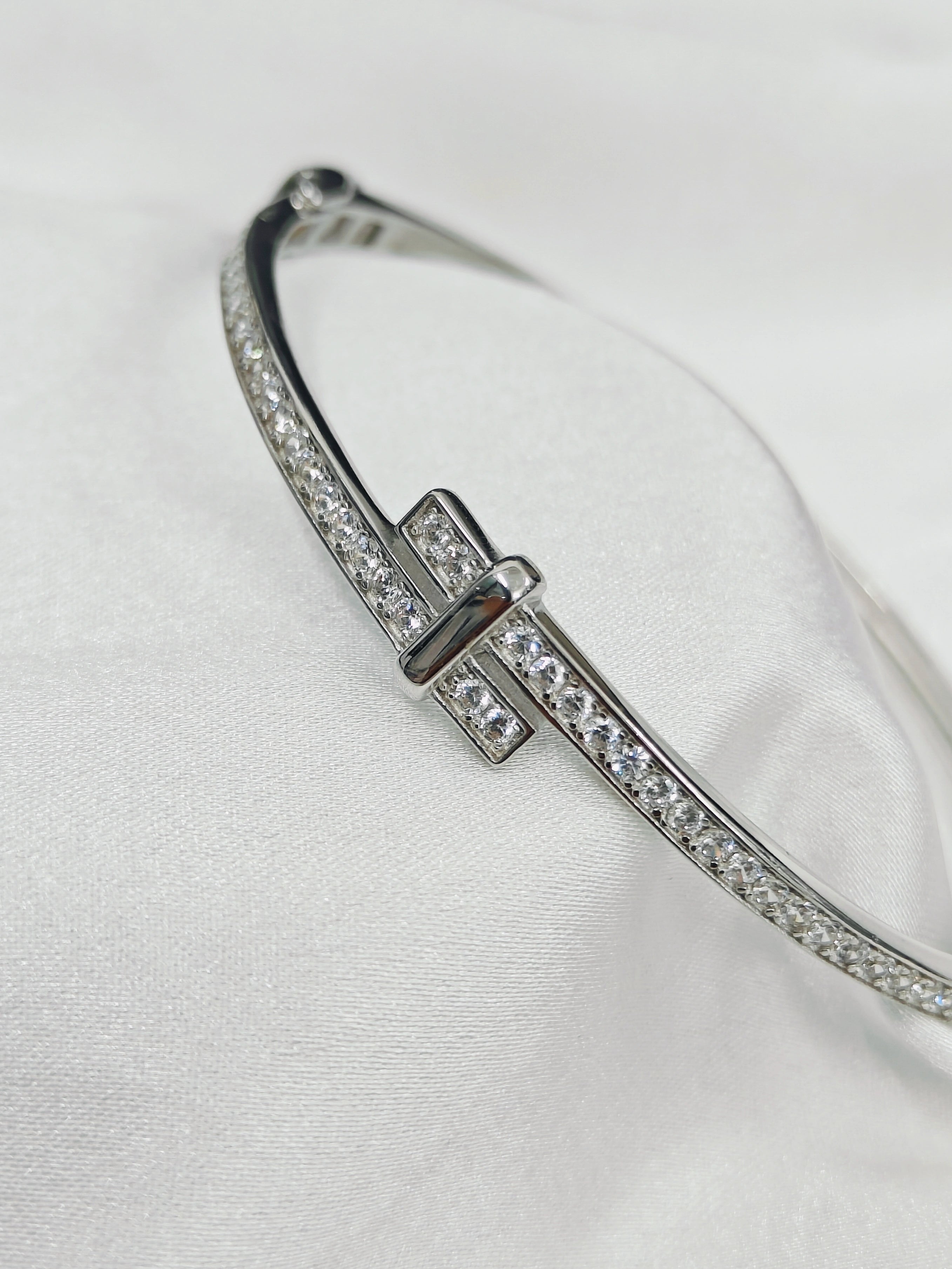 Silver bracelet with clear stones on a white background