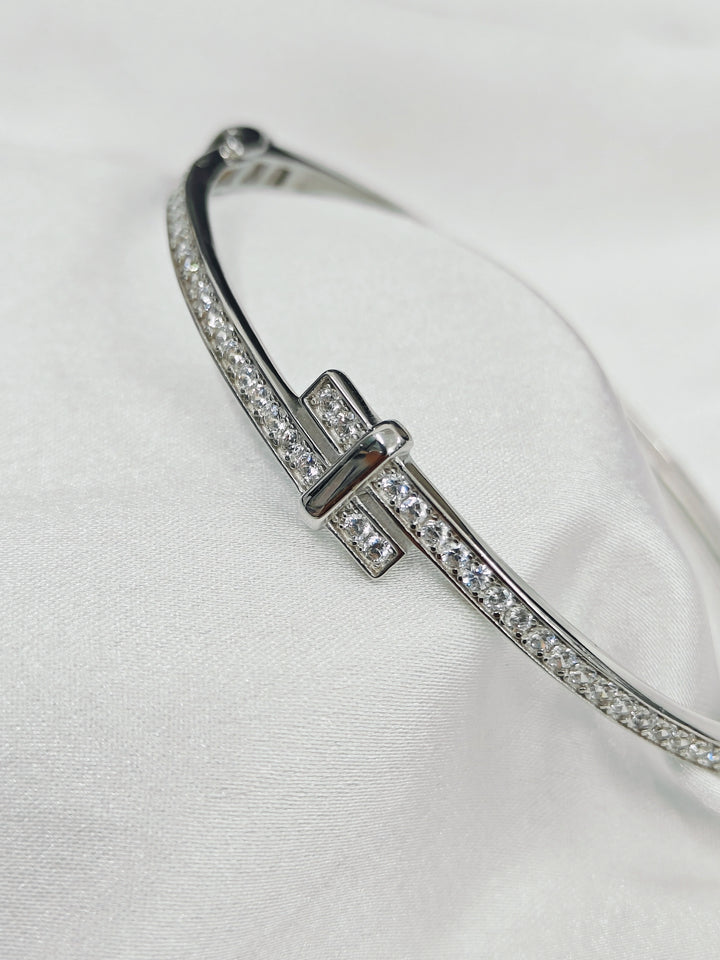 Silver bracelet with clear stones on a white background