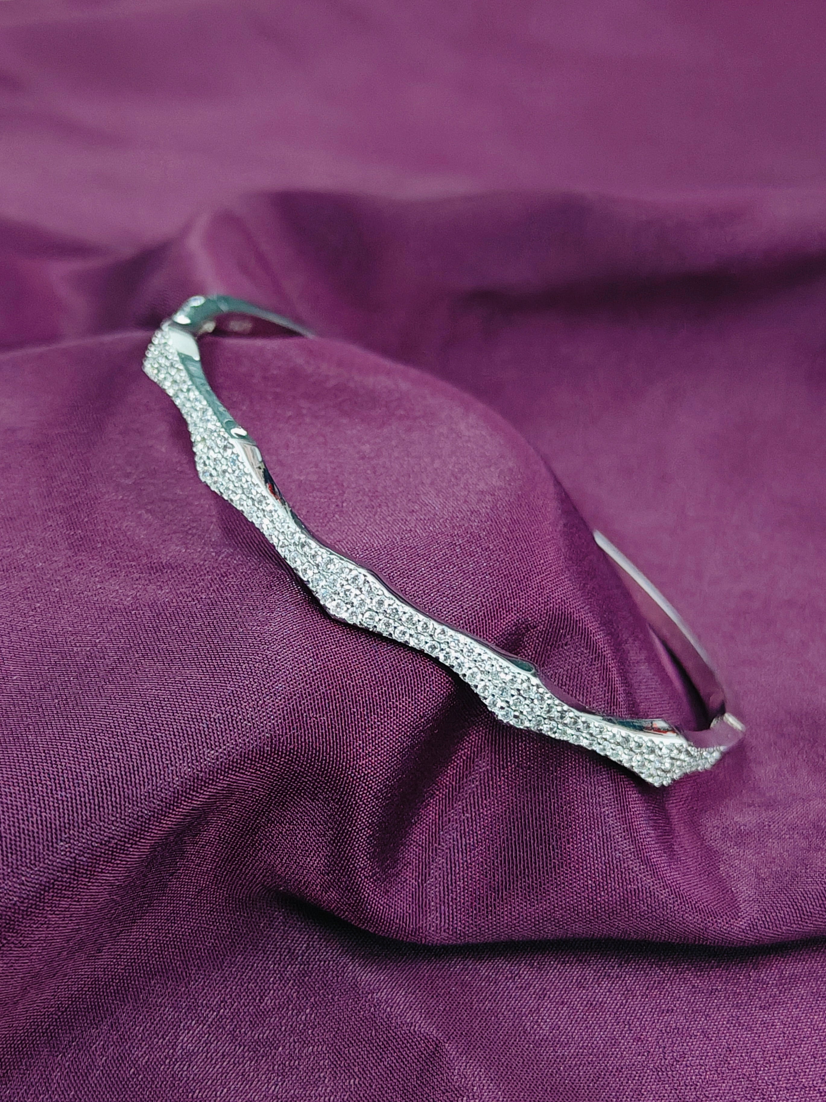Silver necklace on a purple fabric background