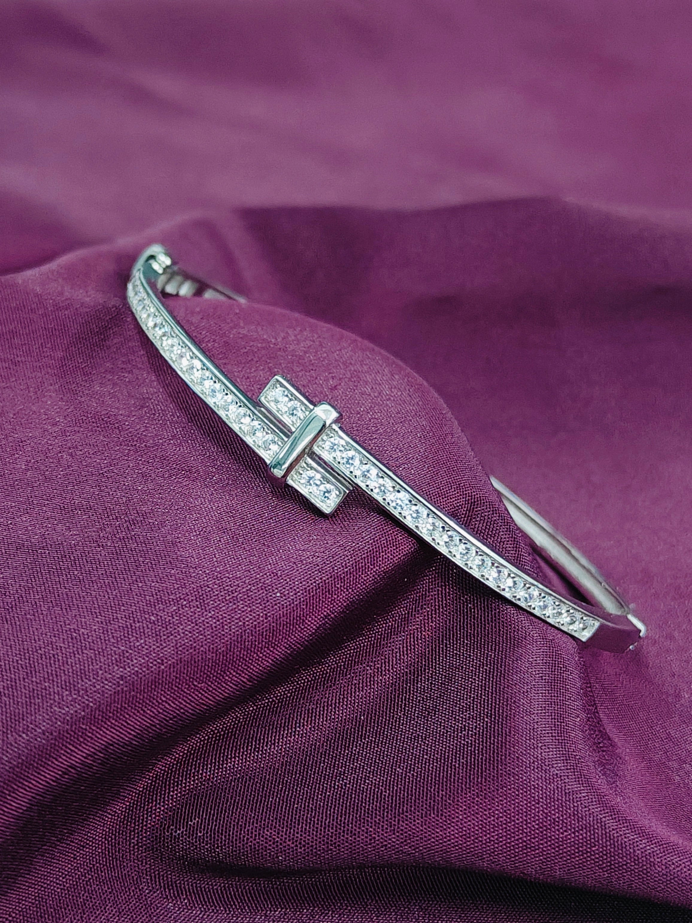 Silver bracelet with clear stones on a purple fabric background