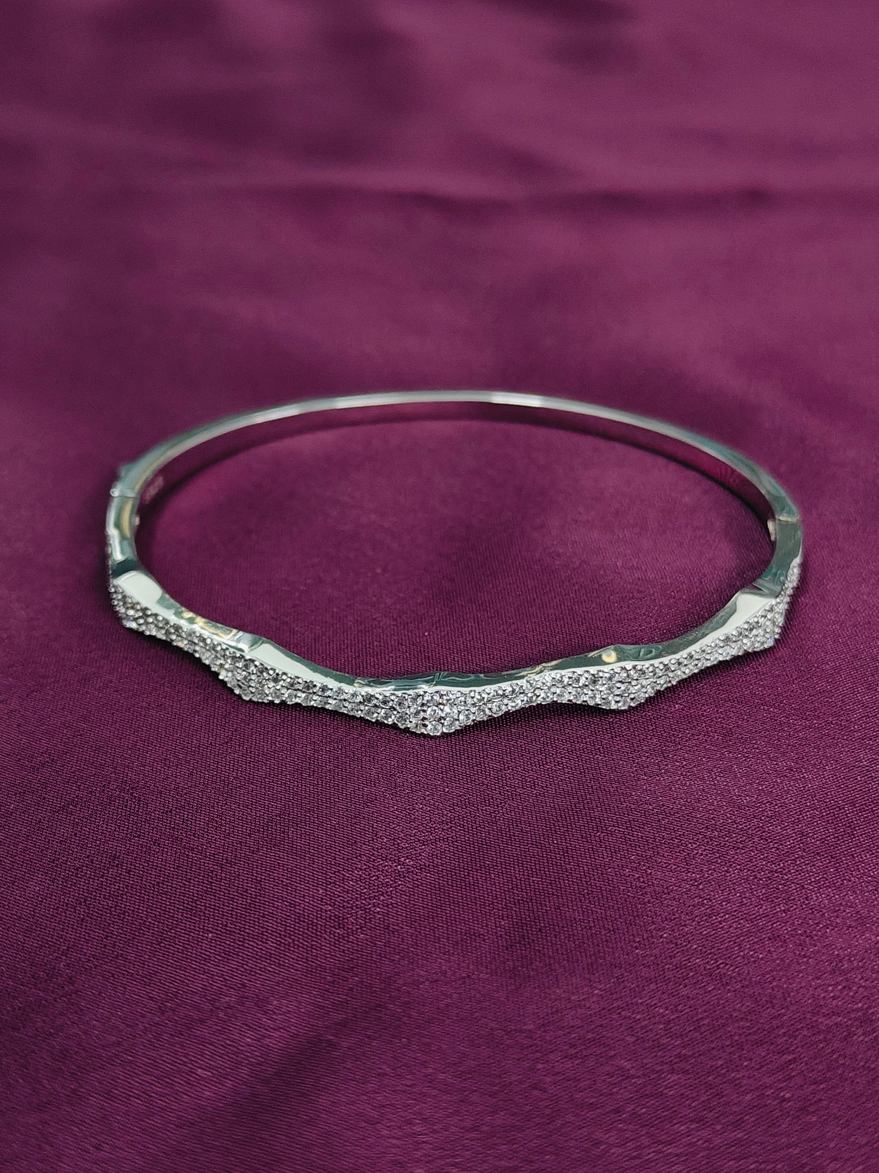 Silver bracelet on a purple fabric background