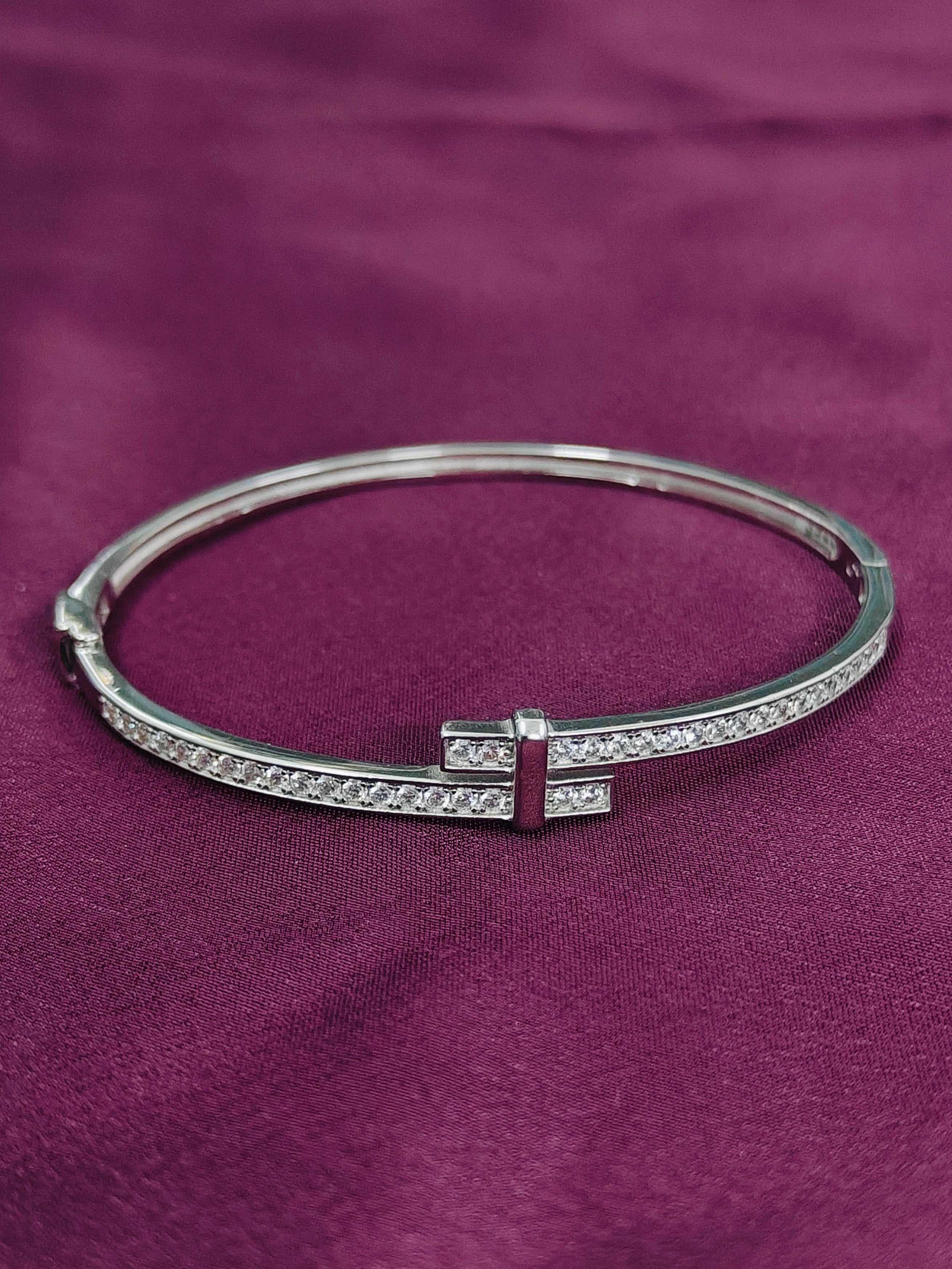 Silver bracelet with gemstones on a purple fabric background