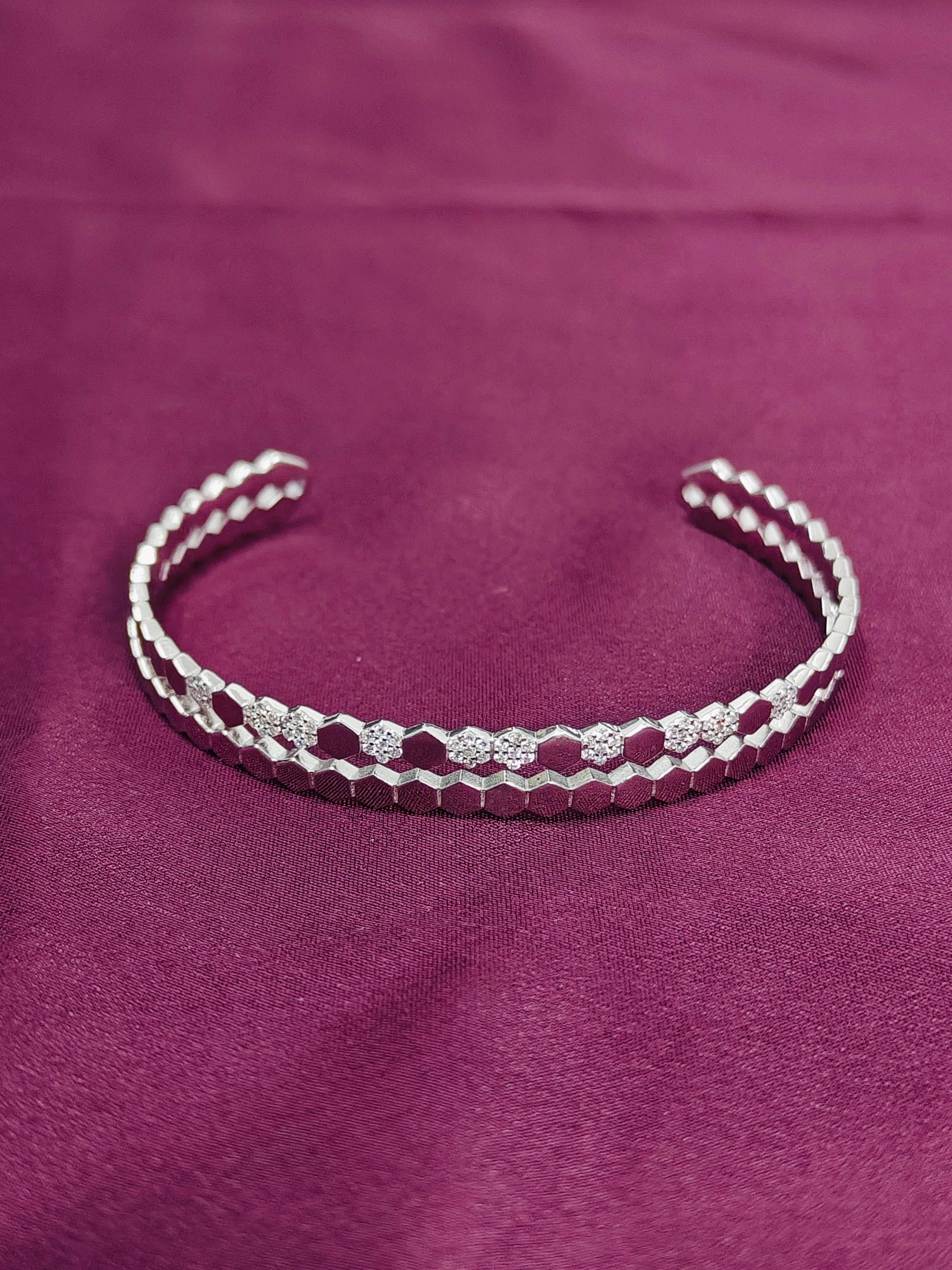 Silver beaded bracelet on a purple fabric background