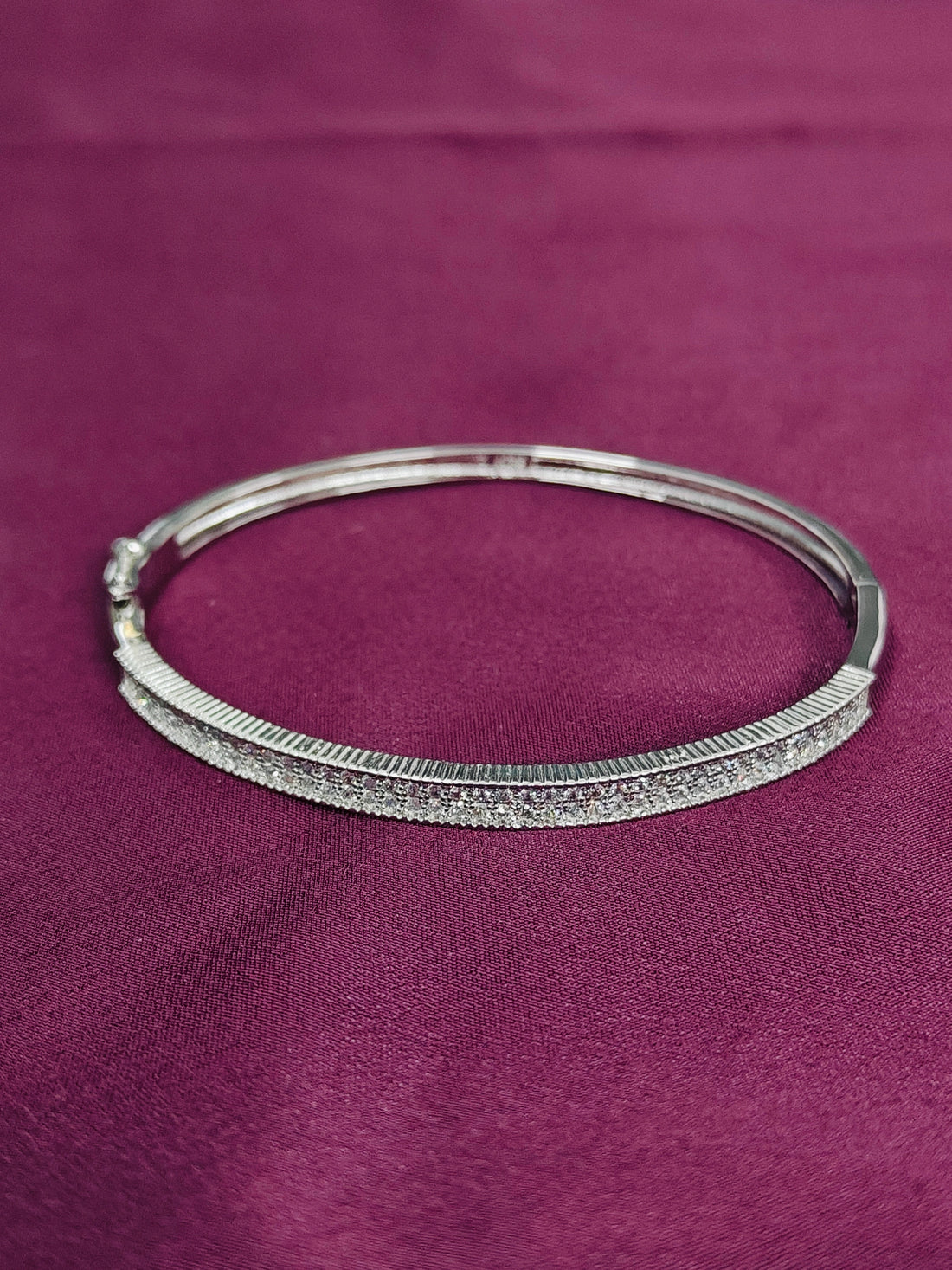 Silver bracelet on a purple fabric background