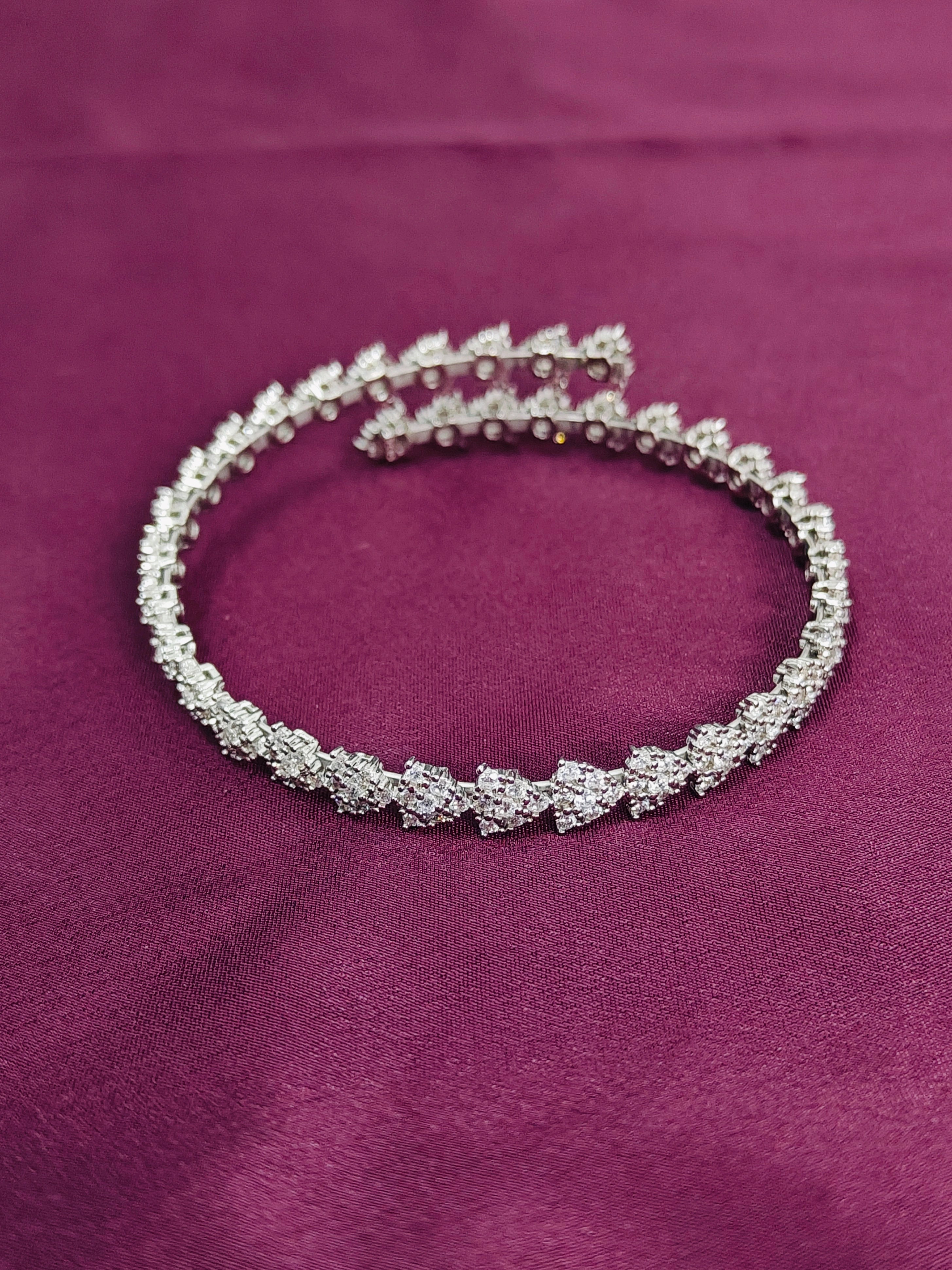Silver bracelet with clear stones on a purple fabric background