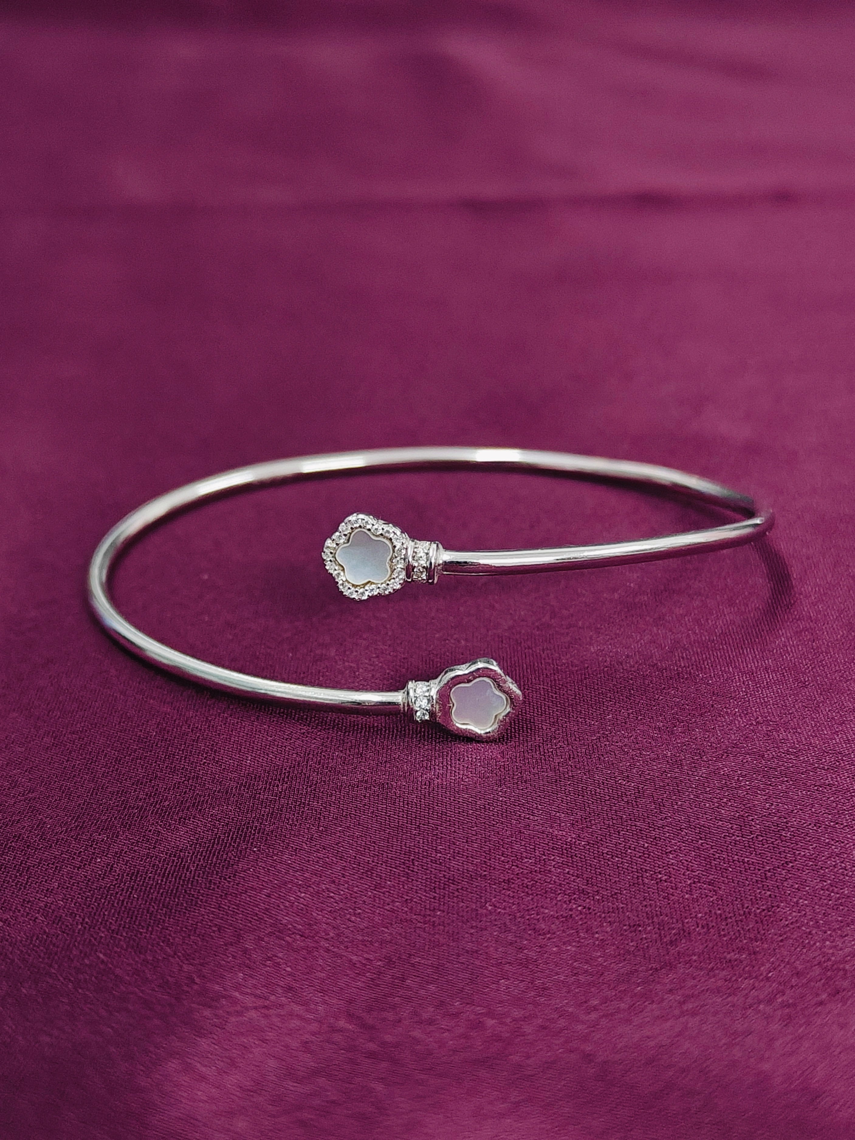 Silver bracelet with gemstone ends on a purple fabric background