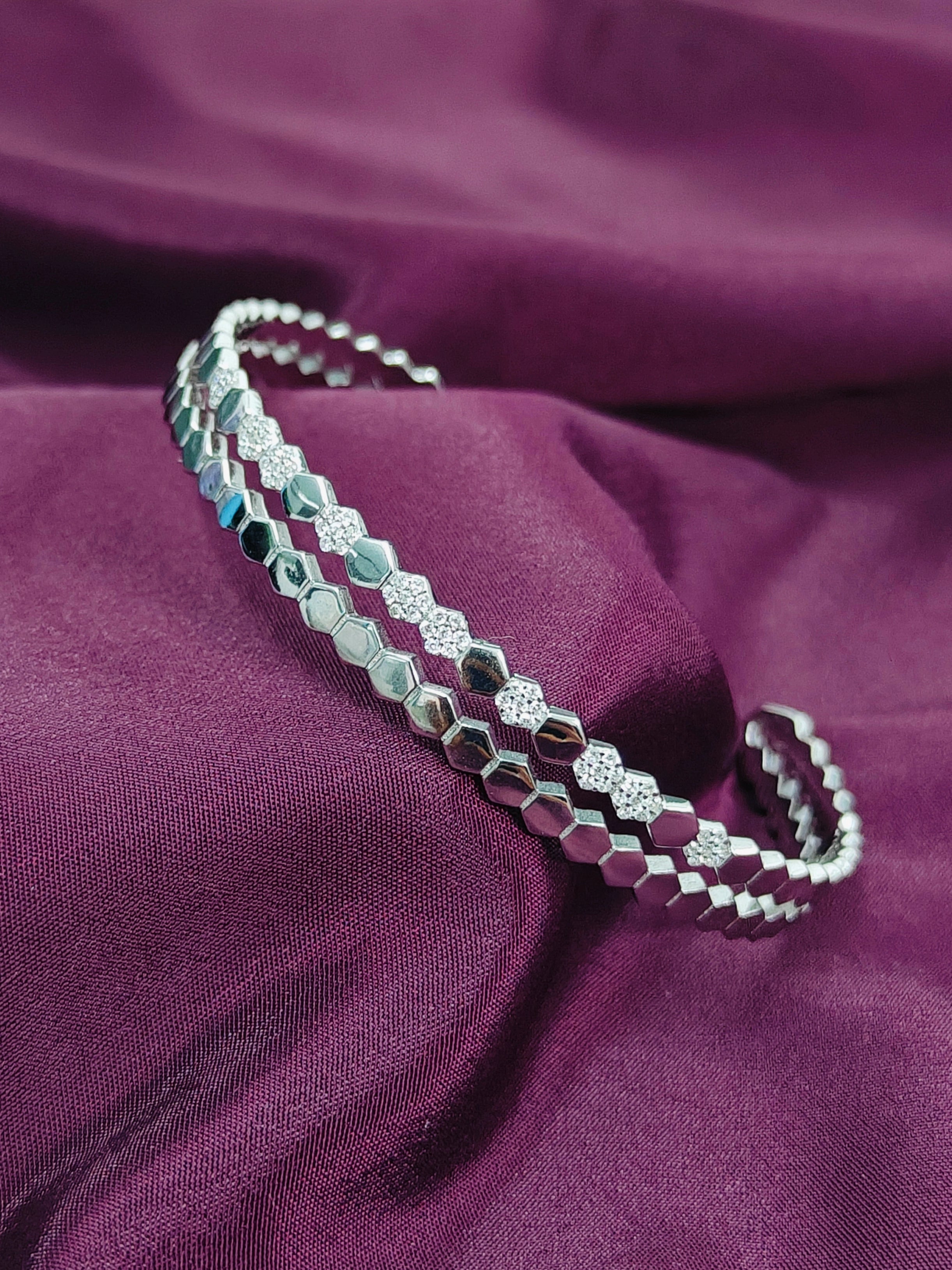 Silver bracelet on a purple fabric background