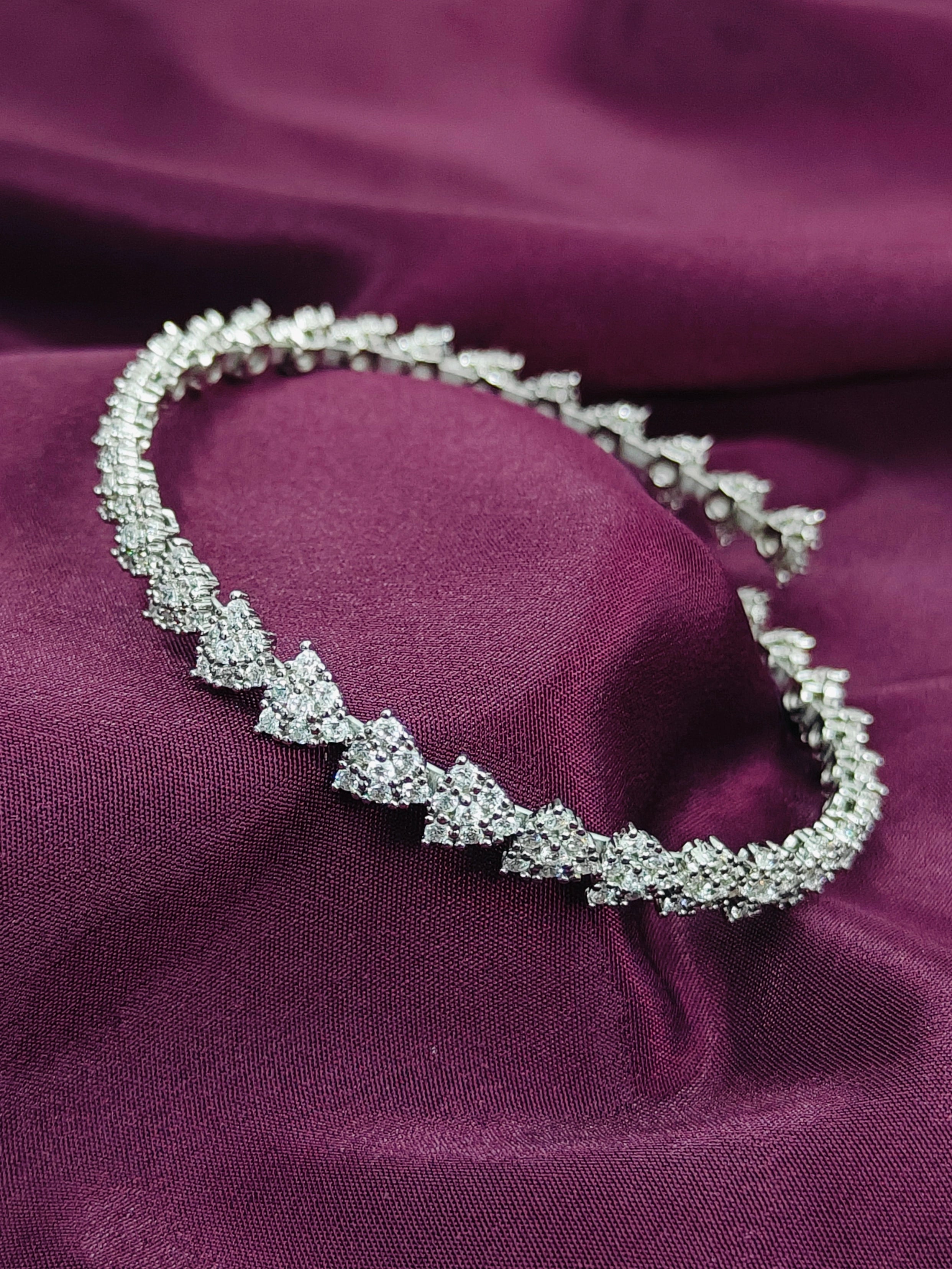 Silver bracelet with clear stones on a purple fabric background
