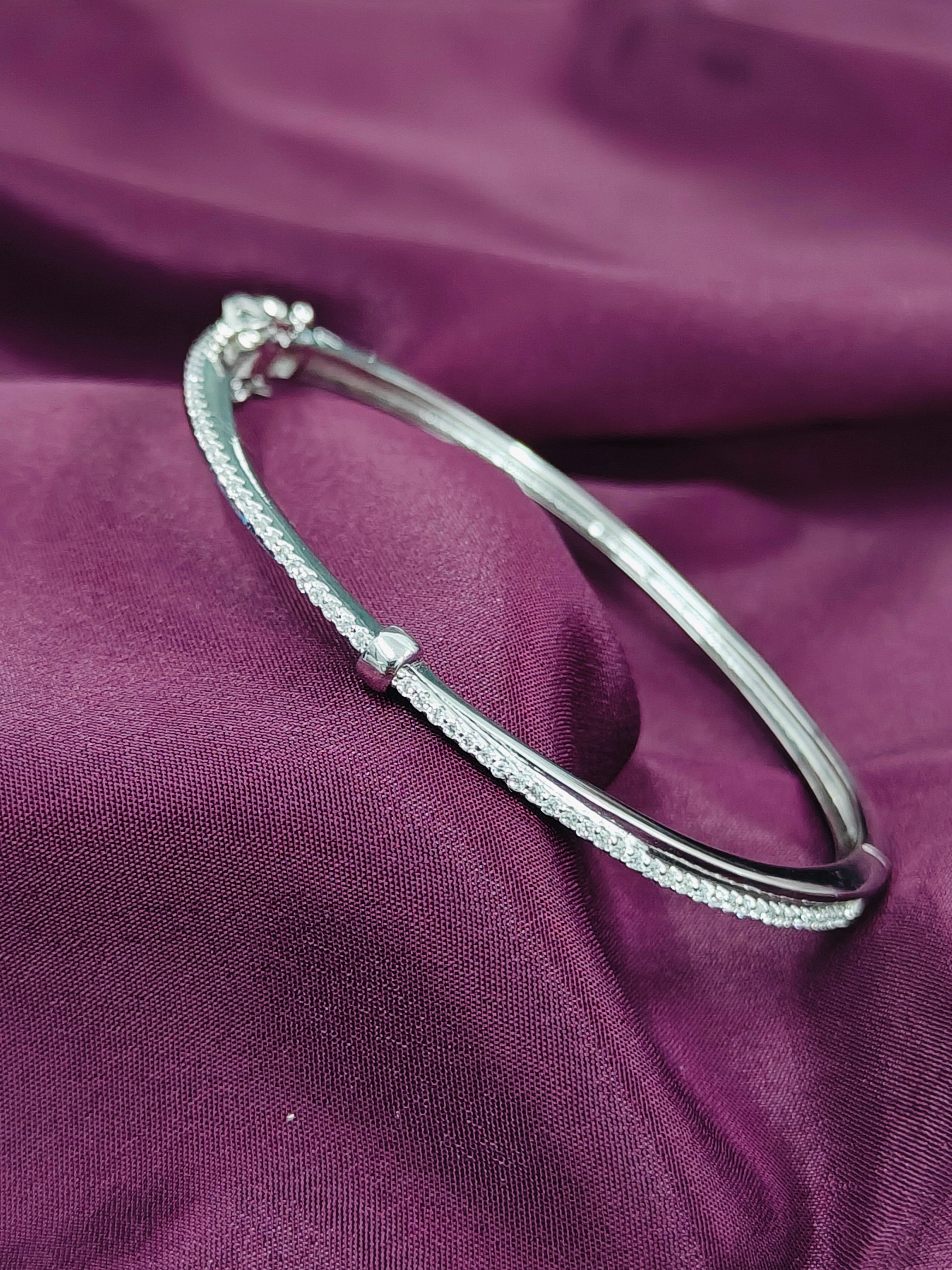 Silver bracelet on a purple fabric background