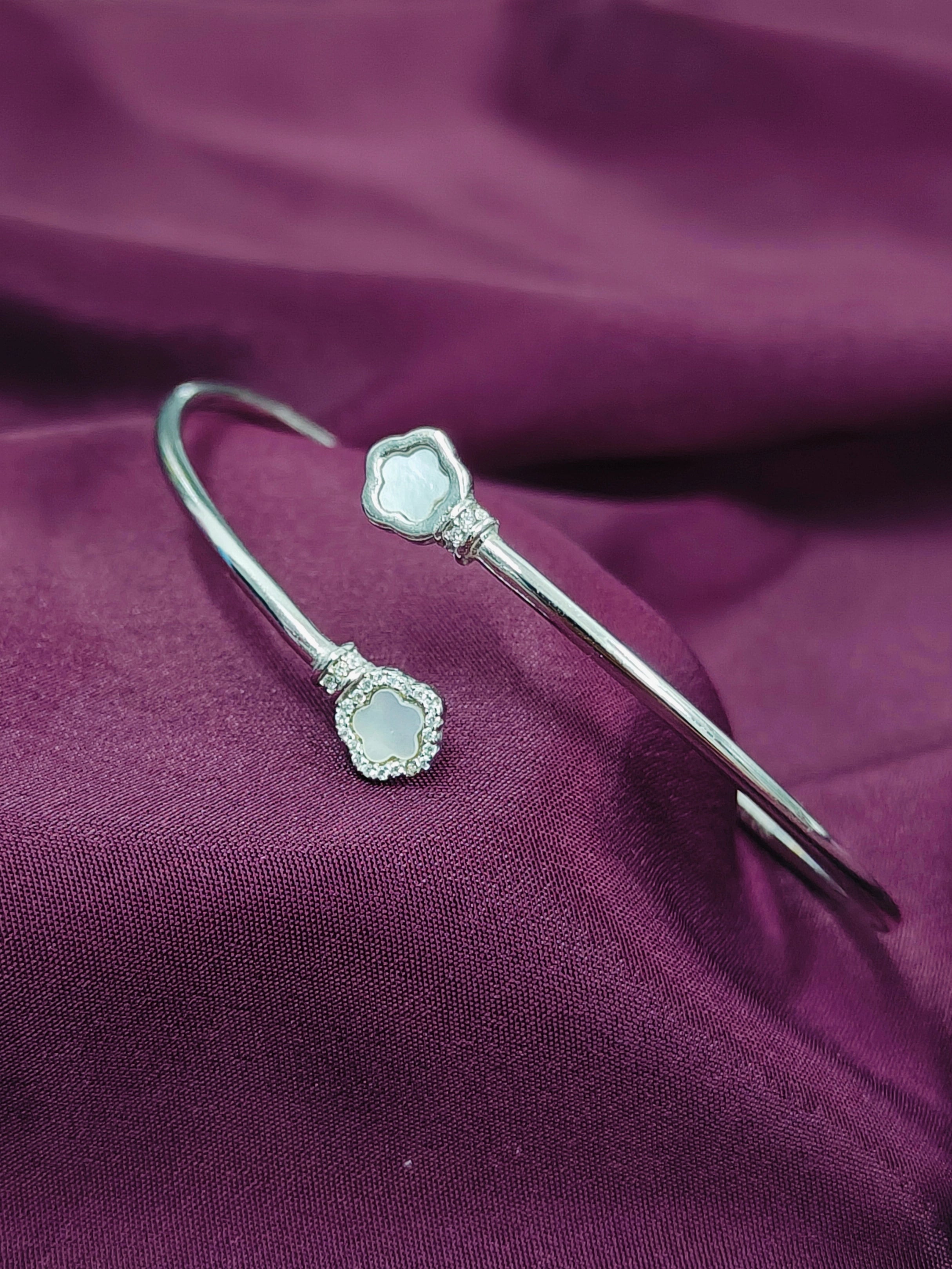 Silver hairpin with a central gemstone on a purple fabric background