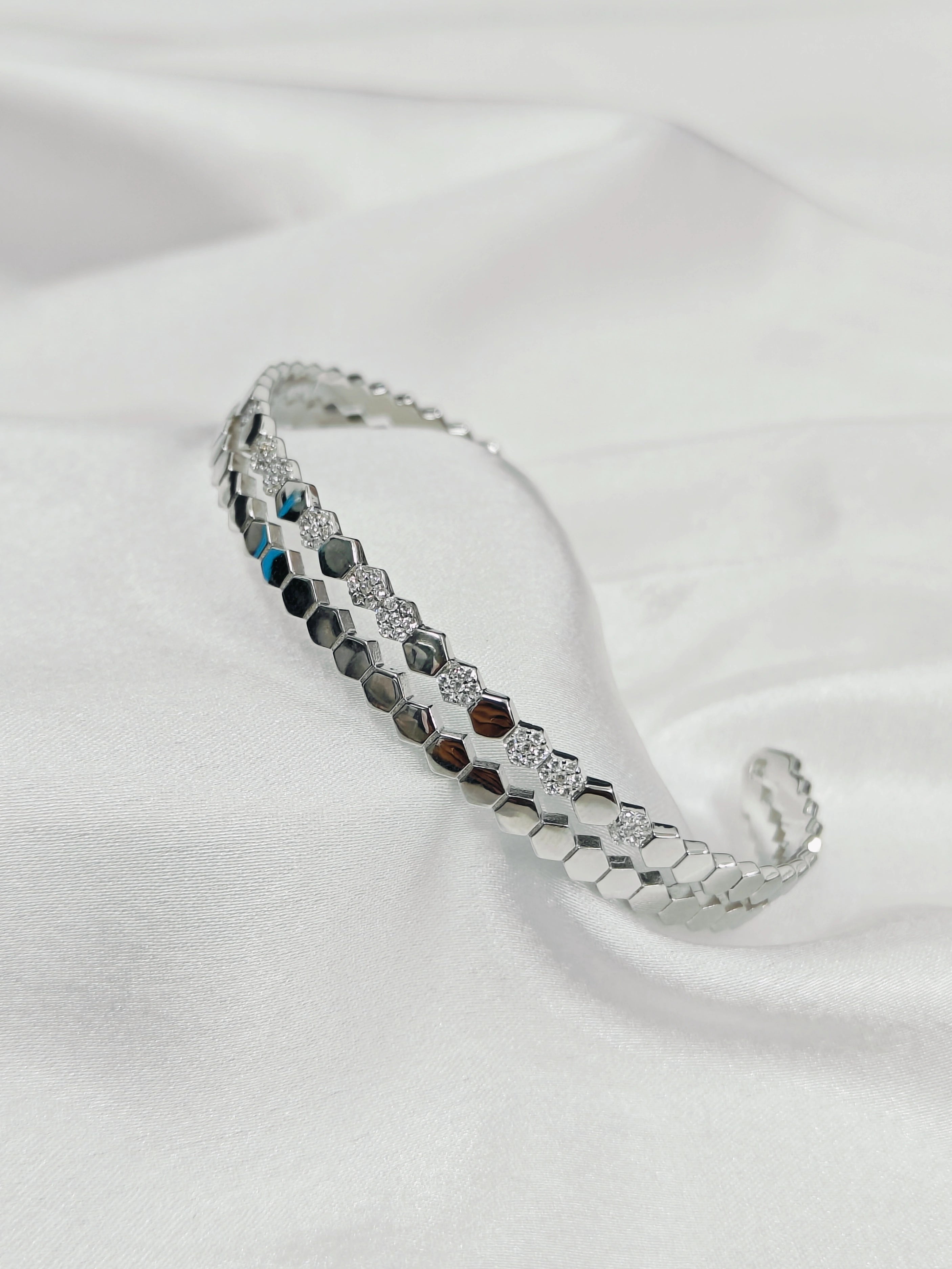 Silver bracelet with gemstone accents on a white fabric background