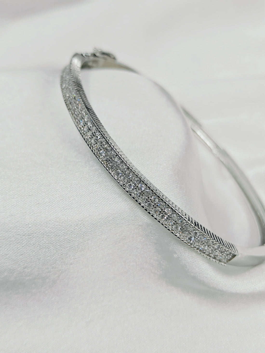 Silver bracelet with small stones on a white background