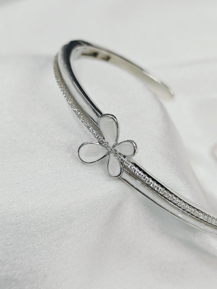 Silver bracelet with a butterfly charm on a light gray background