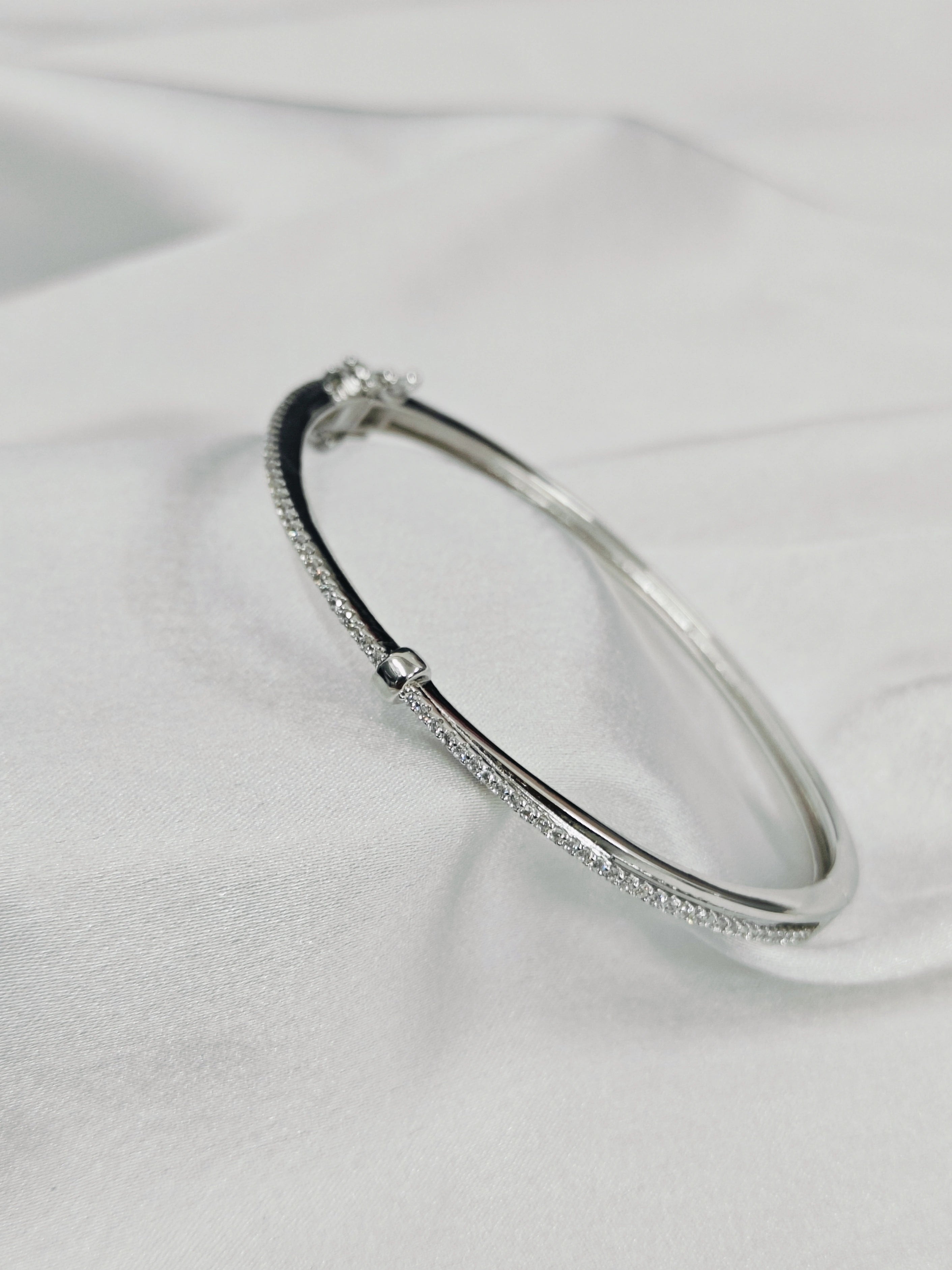 Silver bracelet with small stones on a light gray background